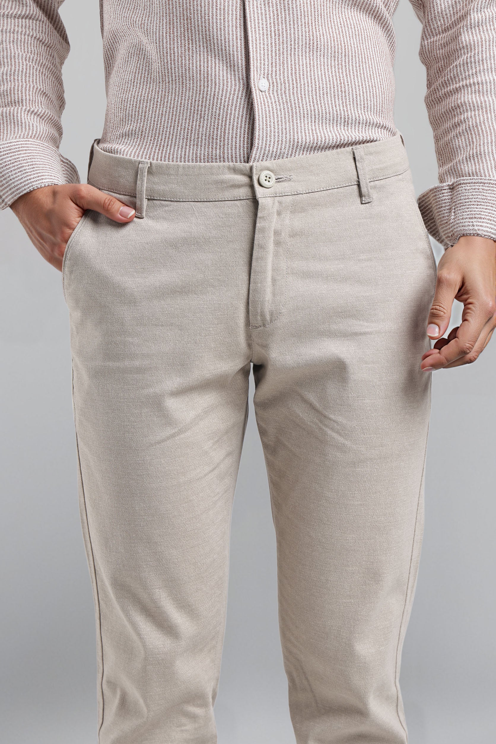 Beige pants worn by a person on a gray background