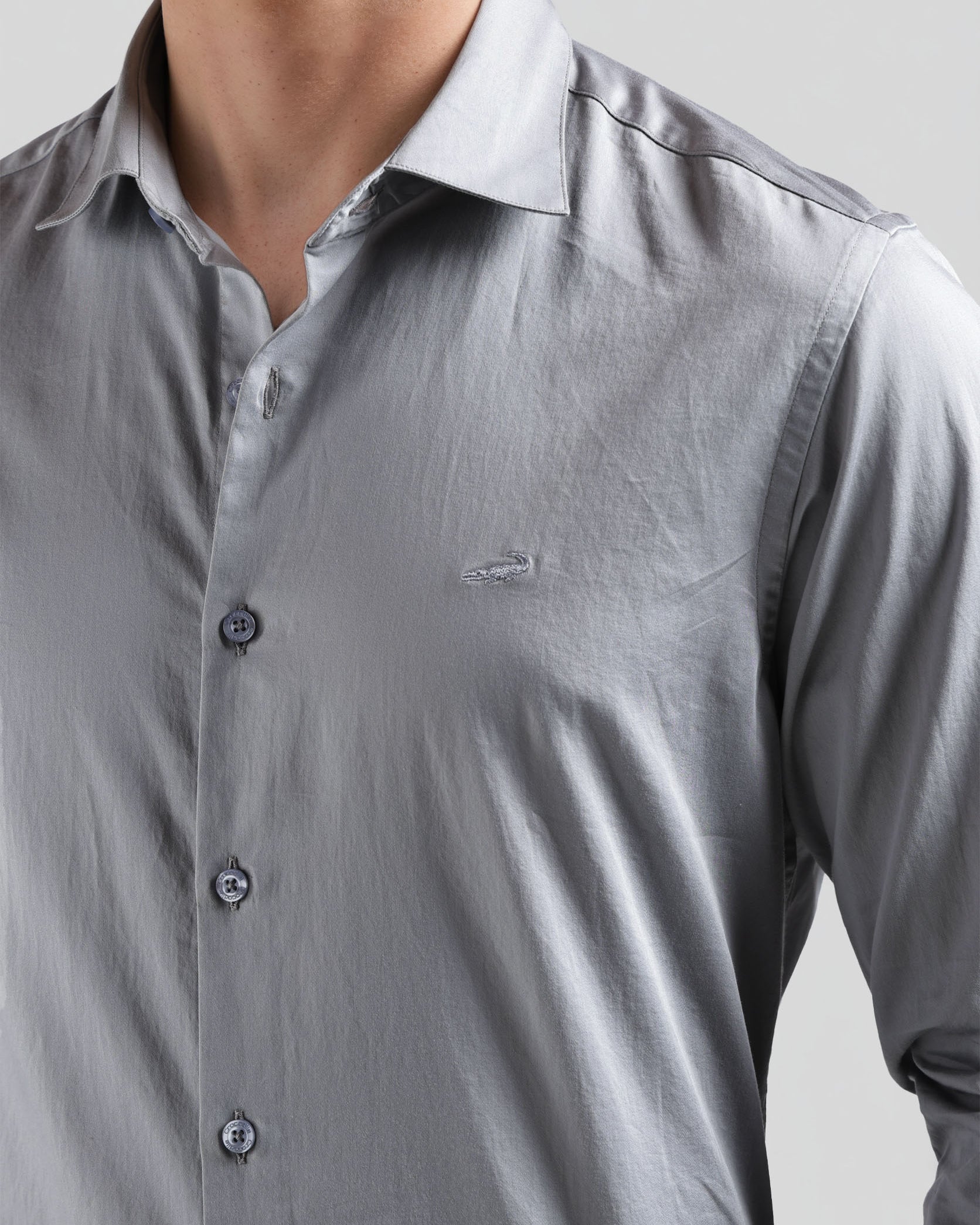 Close-up of a gray button-up shirt with a collar on a plain background