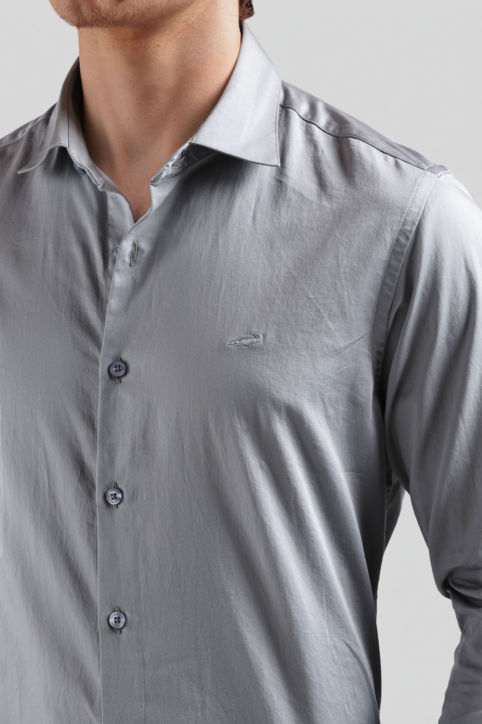 Close-up of a gray button-up shirt with a collar on a plain background