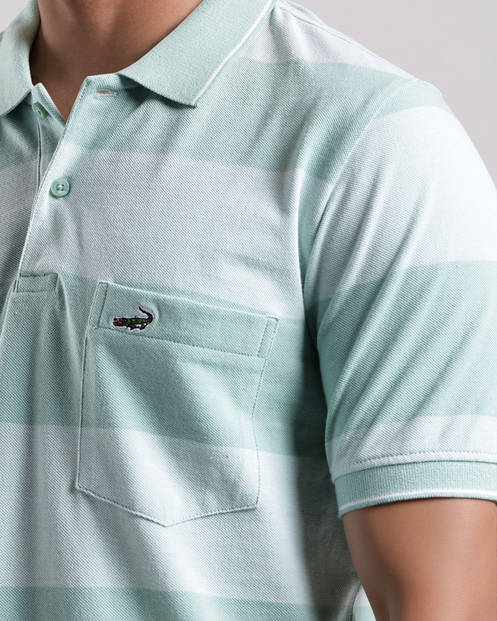 Light blue polo shirt with a brand logo on a neutral background