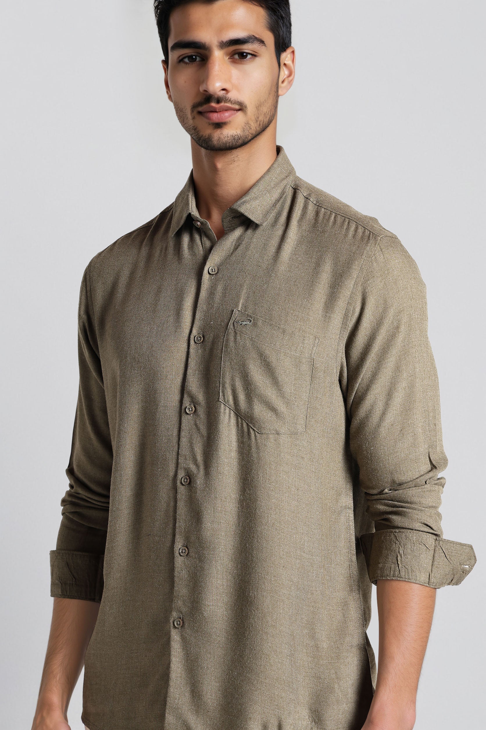 Man wearing a brown button-up shirt against a plain background