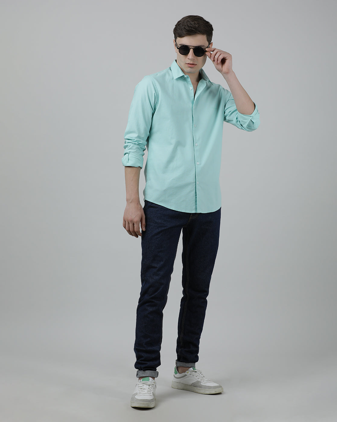 Man wearing a green solid casual full sleeve 100% cotton shirt green with casual styling on a gray background