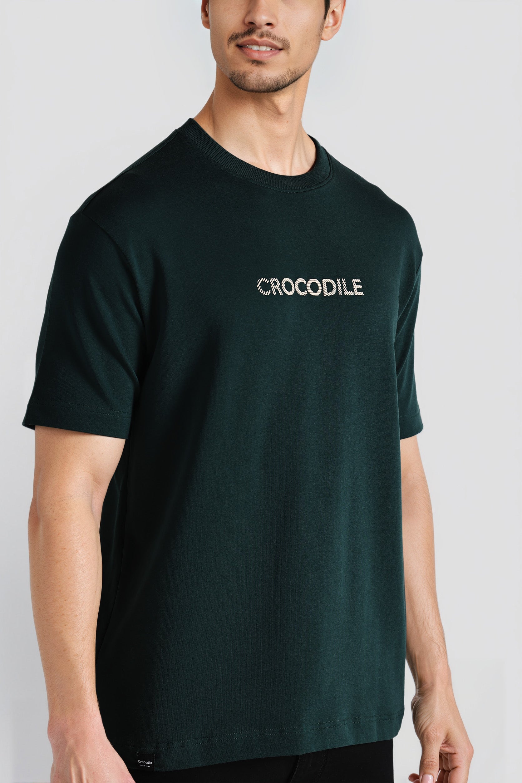 Person wearing a black t-shirt with 'CROCODILE' logo on a light gray background