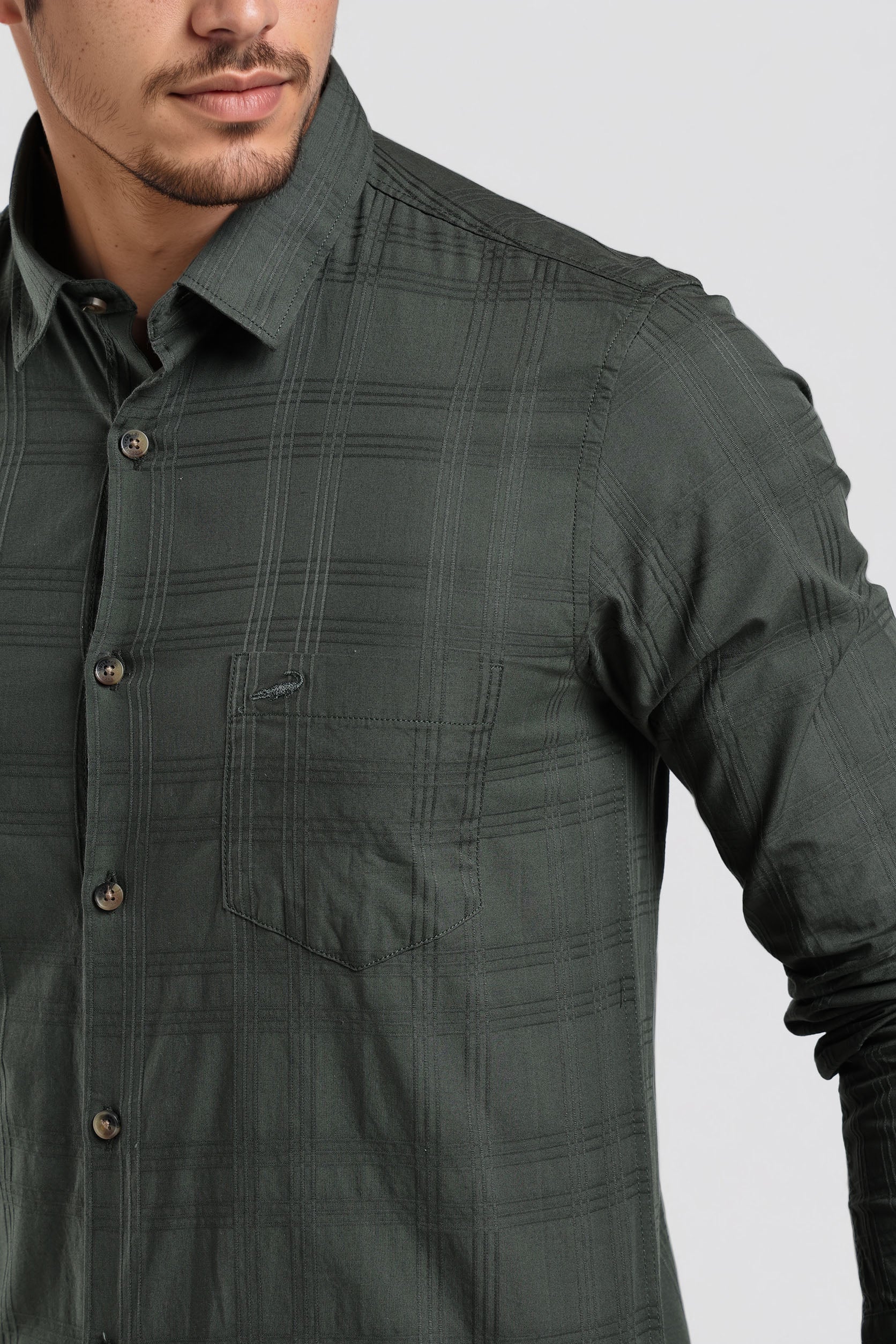 Green checkered shirt worn by a person on a light gray background
