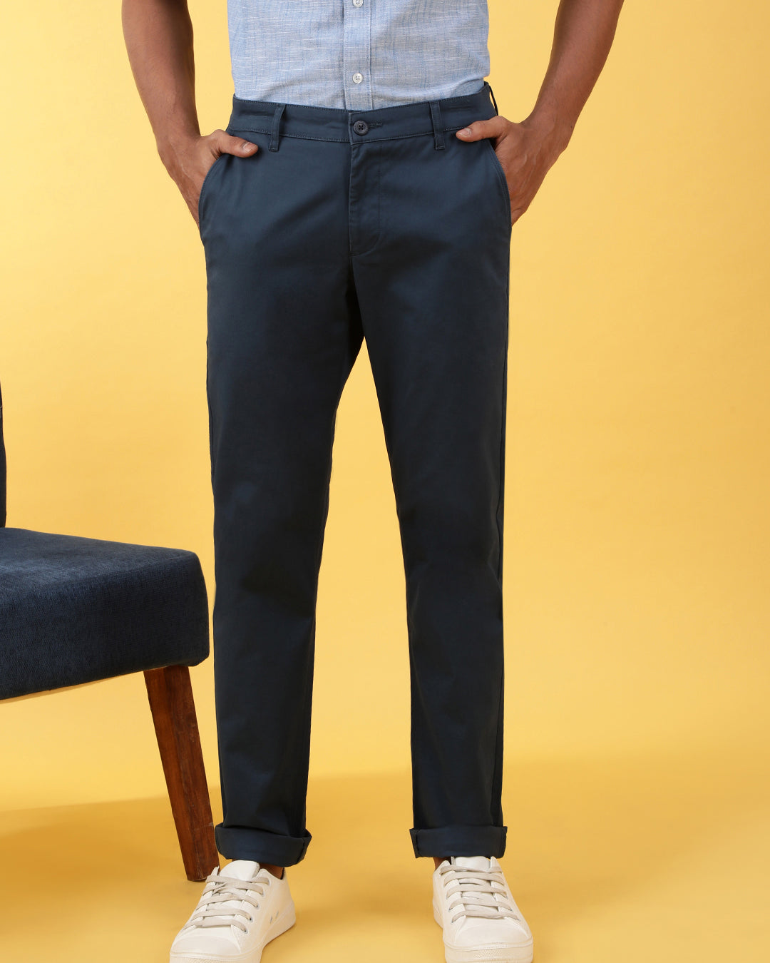 Man wearing a navy solid slim fit casual trouser navy on a light gray background