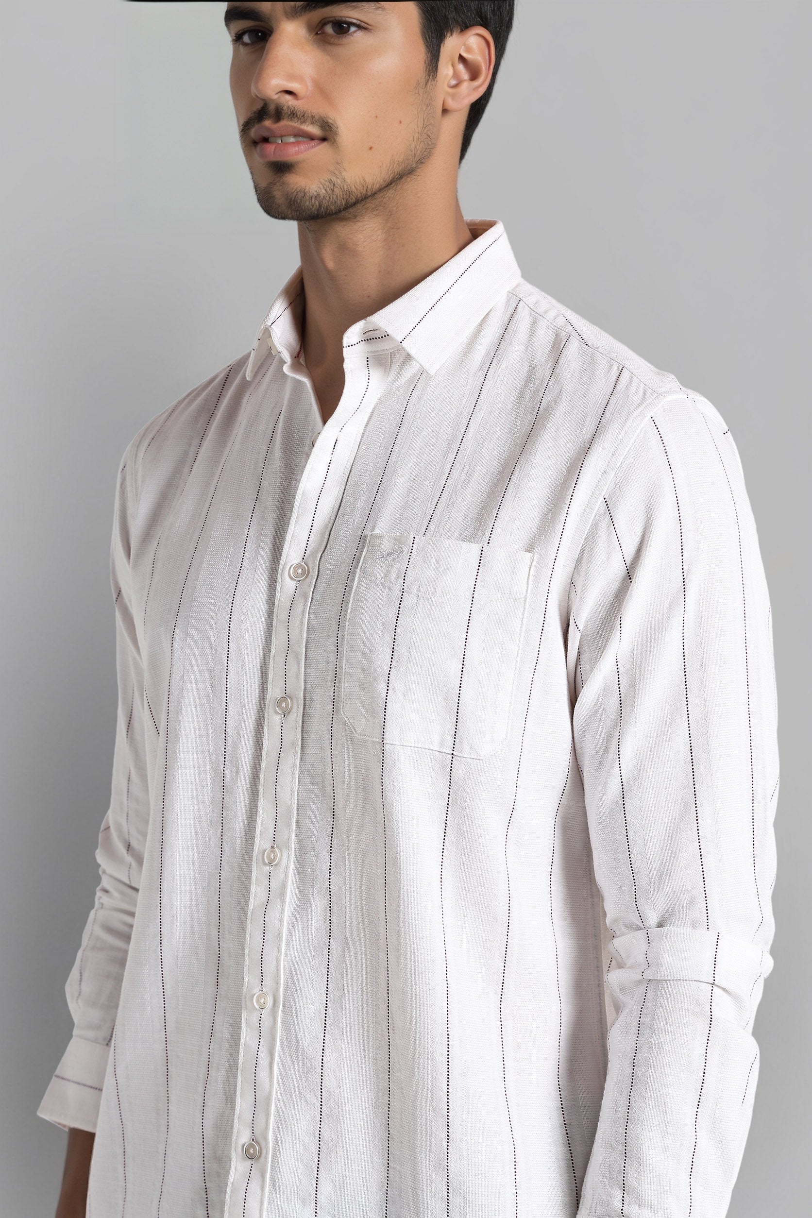 Man wearing a white striped shirt against a gray background
