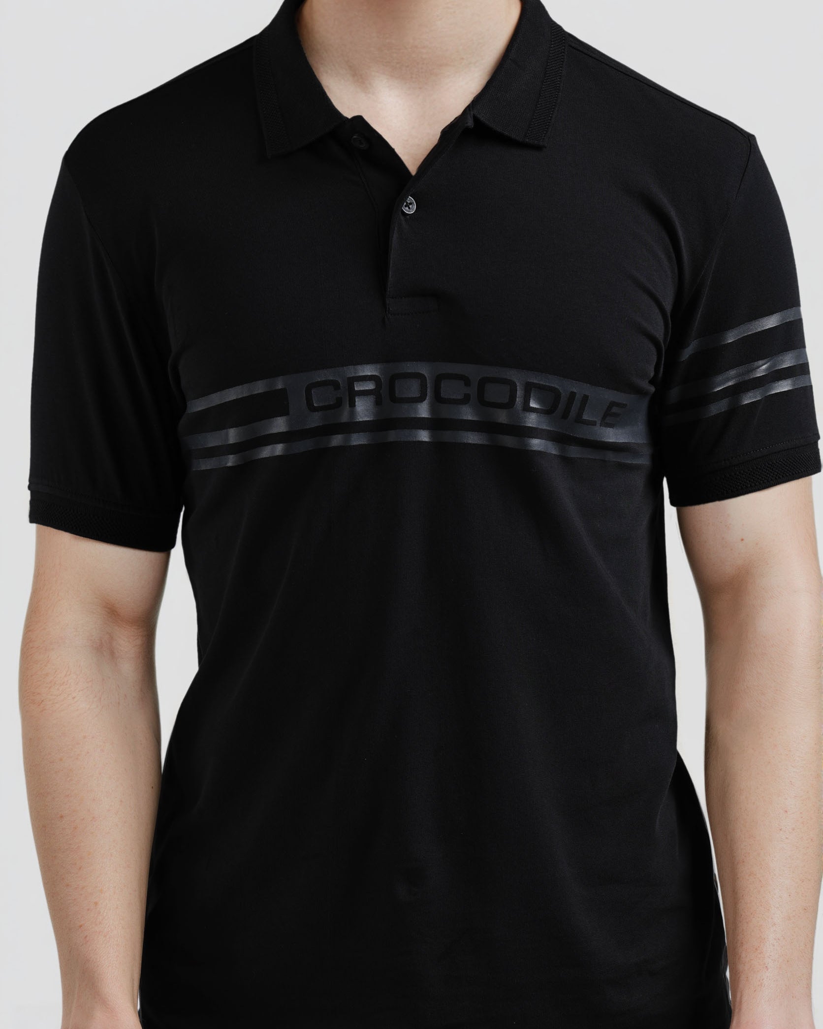 Black polo shirt with 'Crocodile' branding on a white background