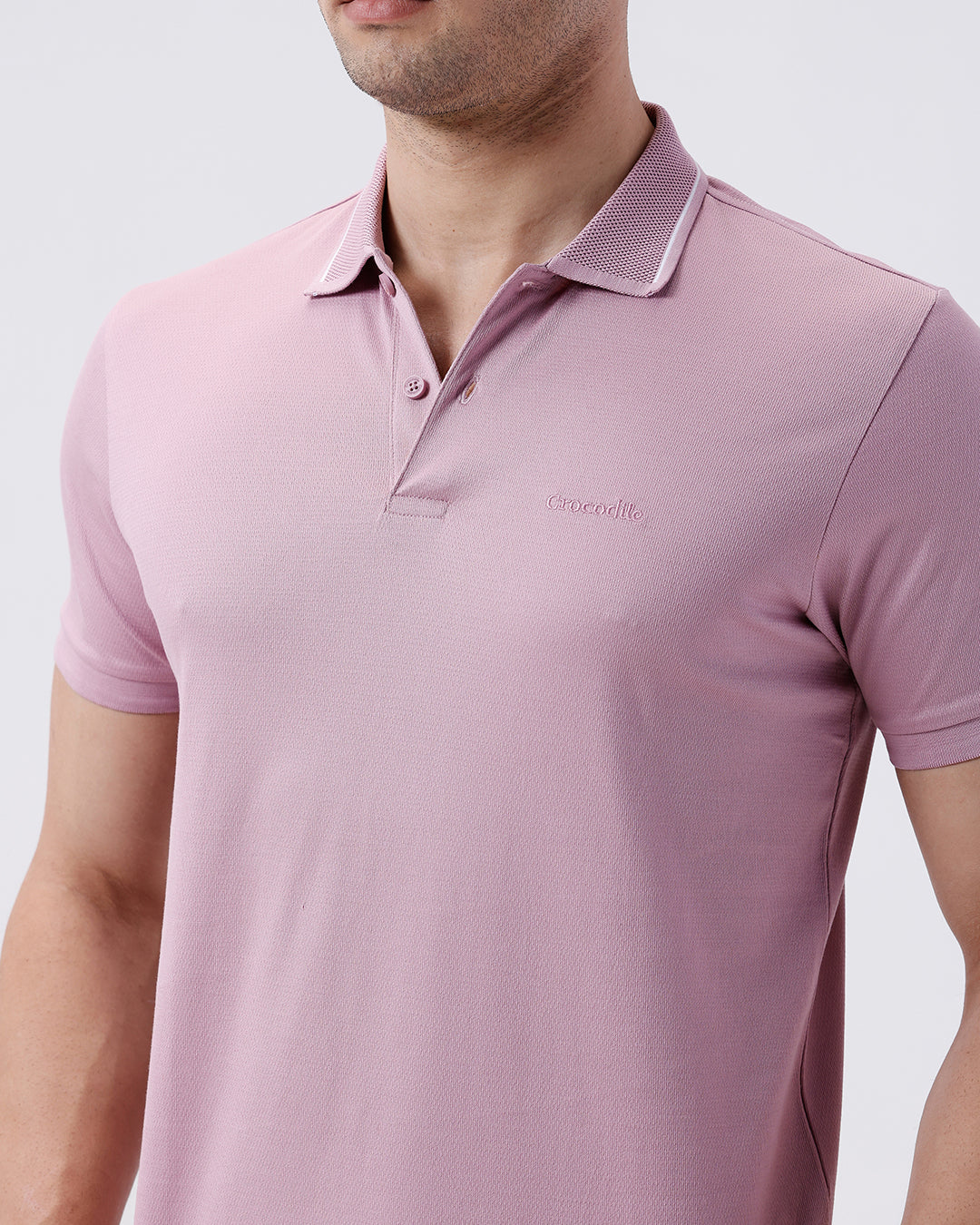 Man wearing a red mercerized subtle textured polo t shirt with casual styling on a gray background