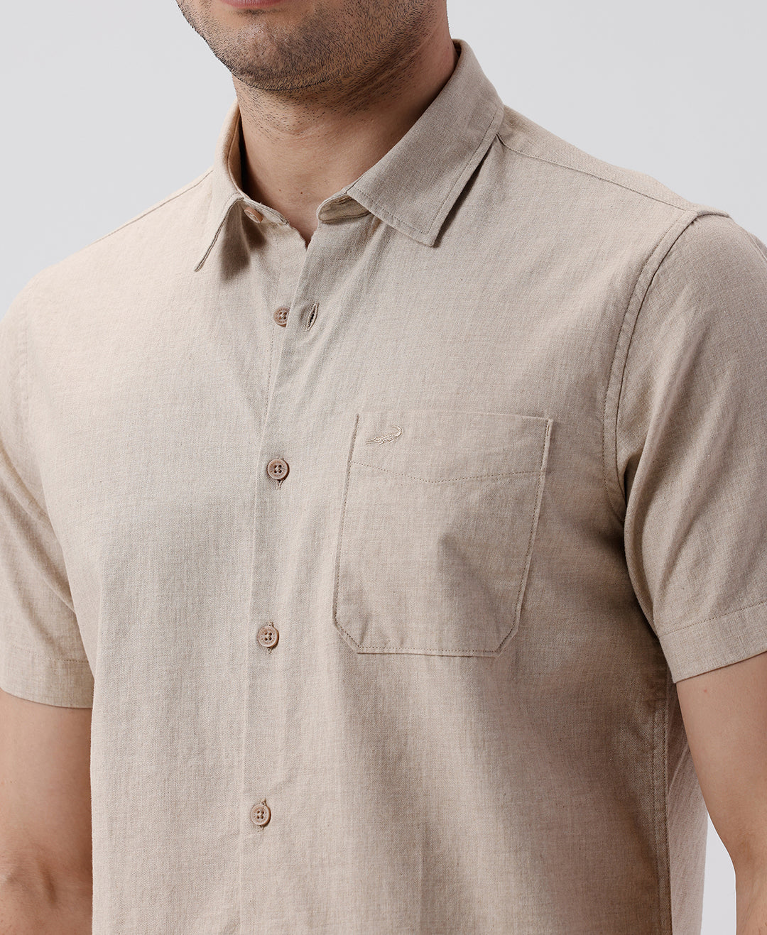 Man wearing a beige melange shirt solid beige on a light gray background