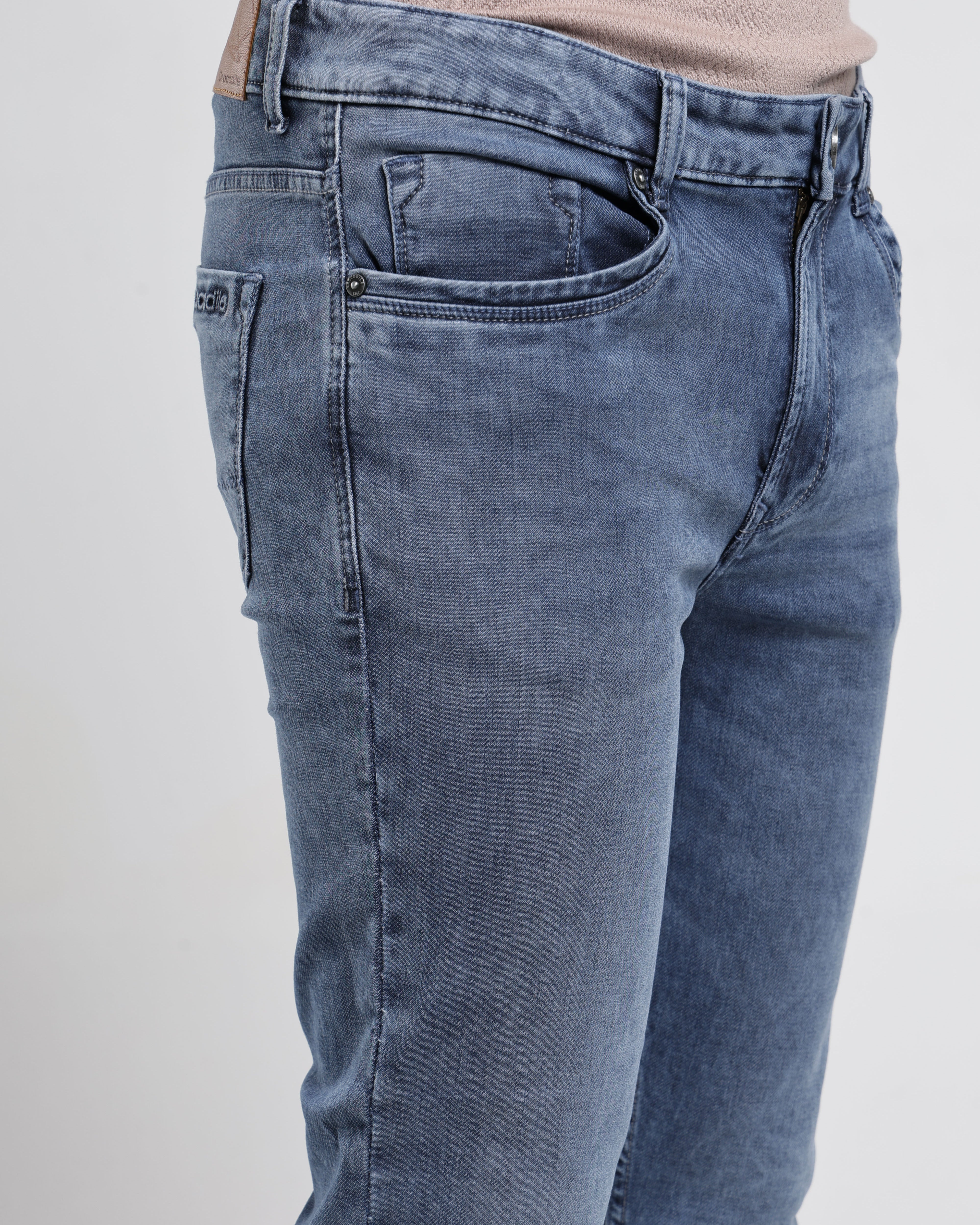 Blue jeans worn by a person on a white background