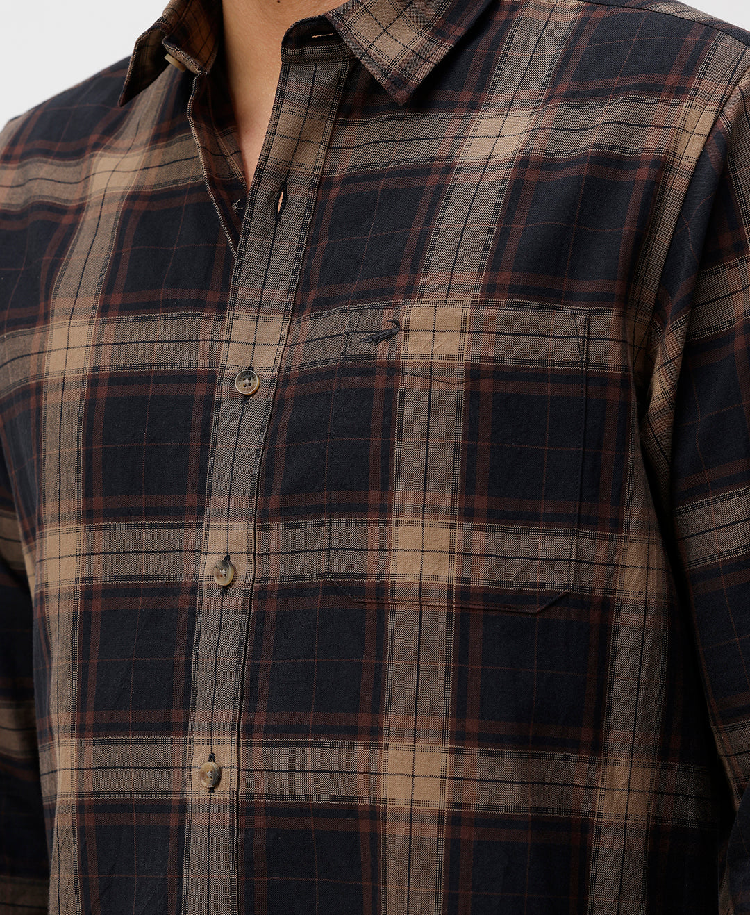 Man wearing a brown oxford checks shirt brown with casual styling on a gray background