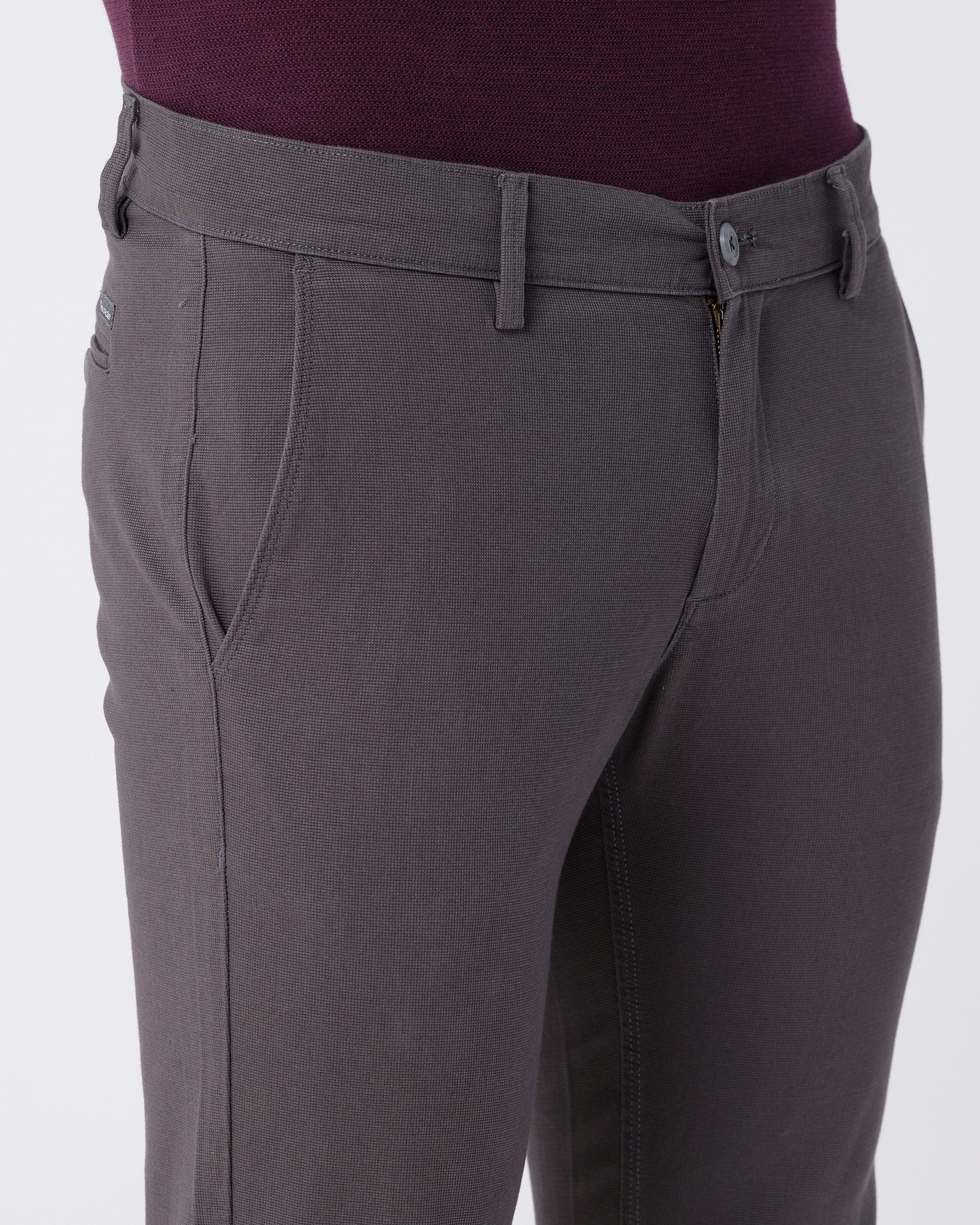 Woman wearing a grey textured essential chinos in dark grey with casual styling on a gray background