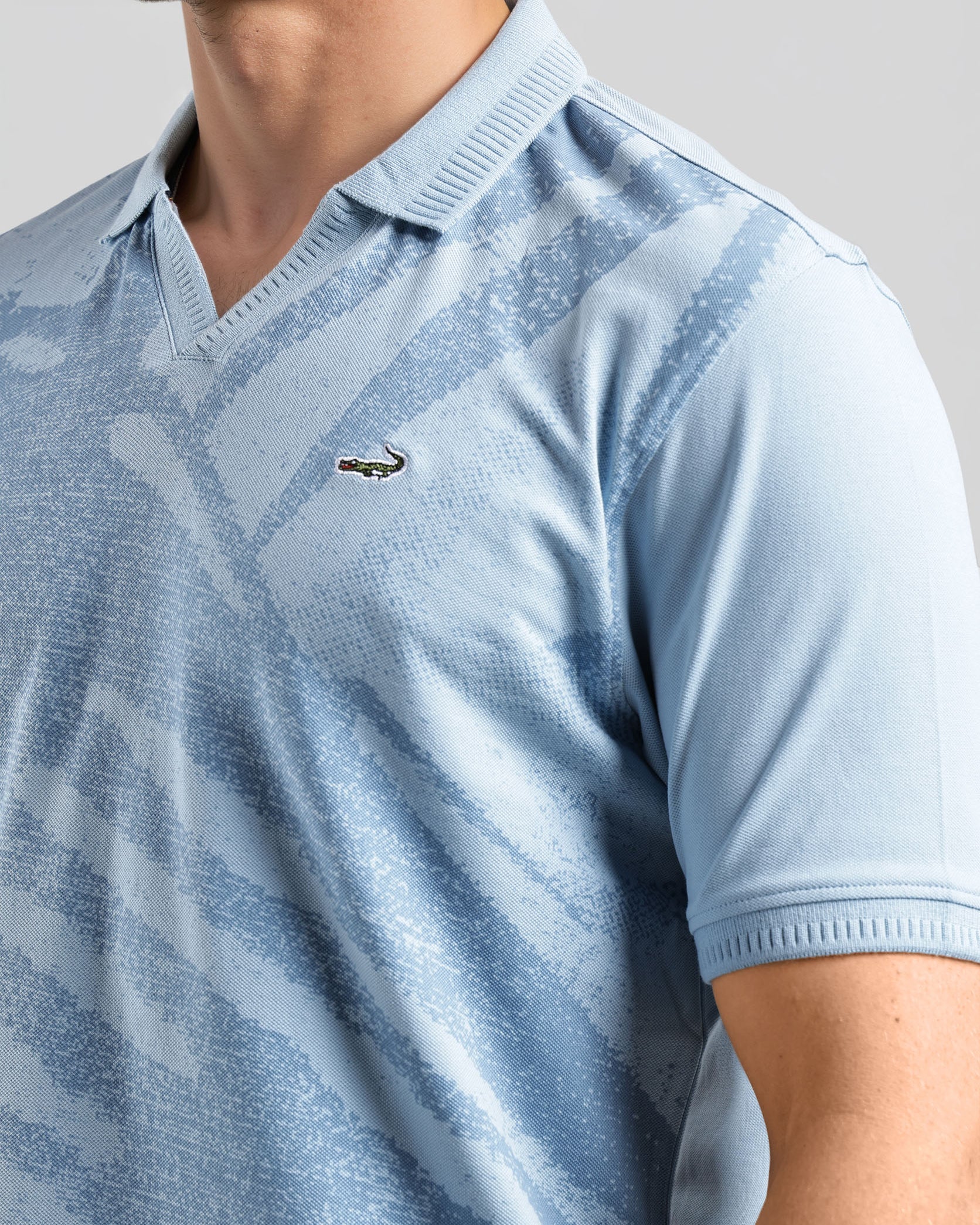 Light blue patterned polo shirt worn by a person on a gray background
