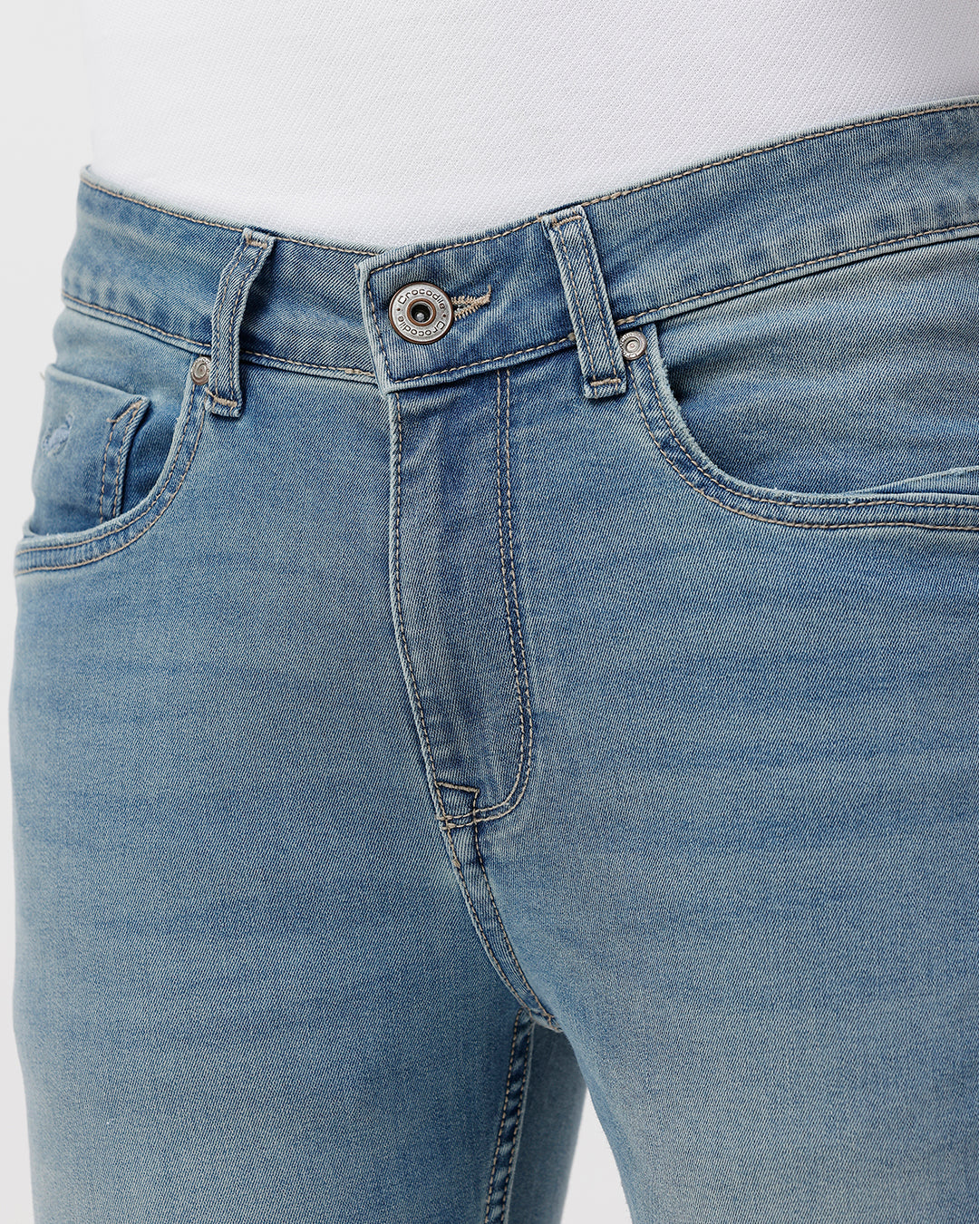 Woman wearing a blue natural fade wash dark blue denim on a light gray background