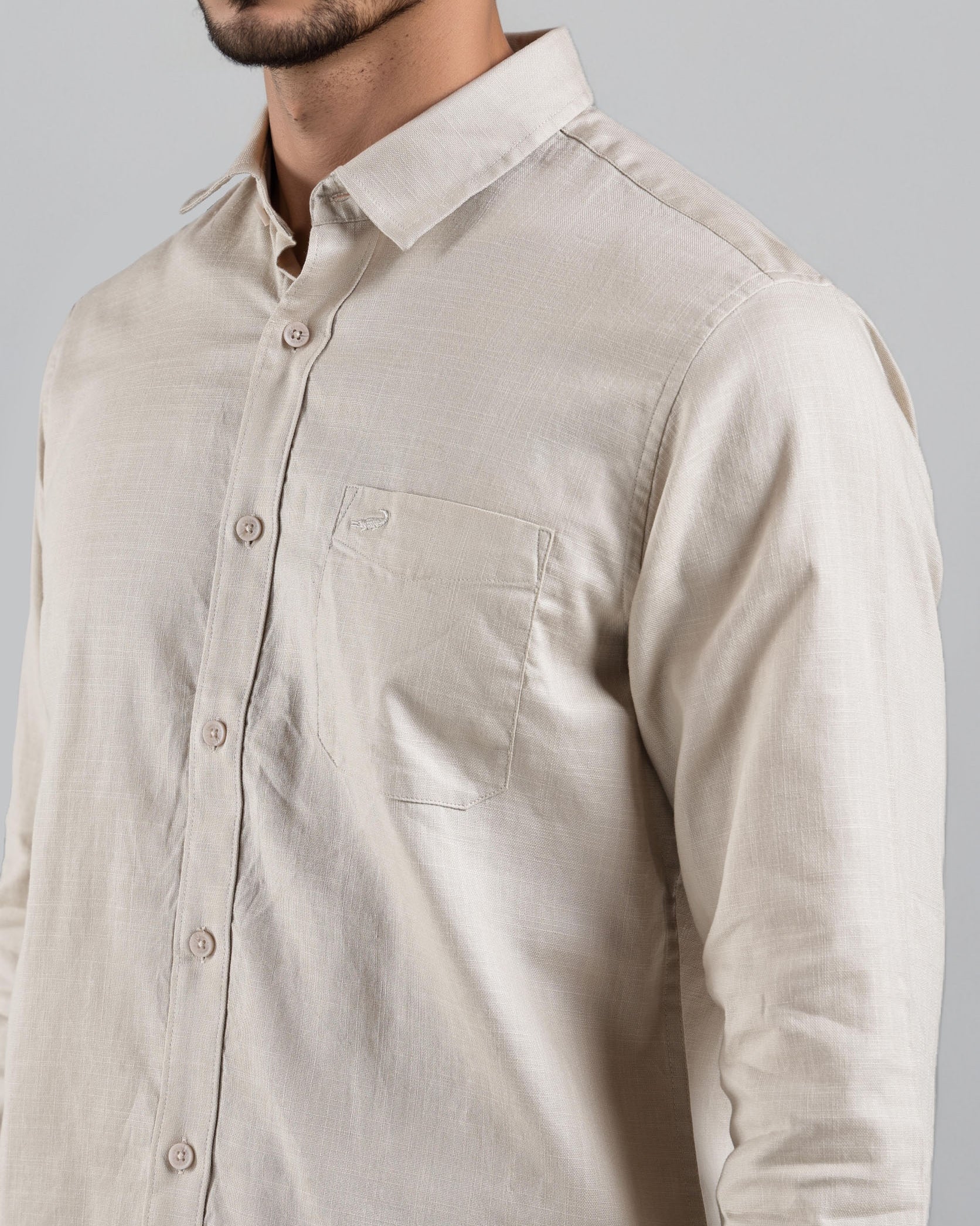 Beige shirt worn by a person on a gray background