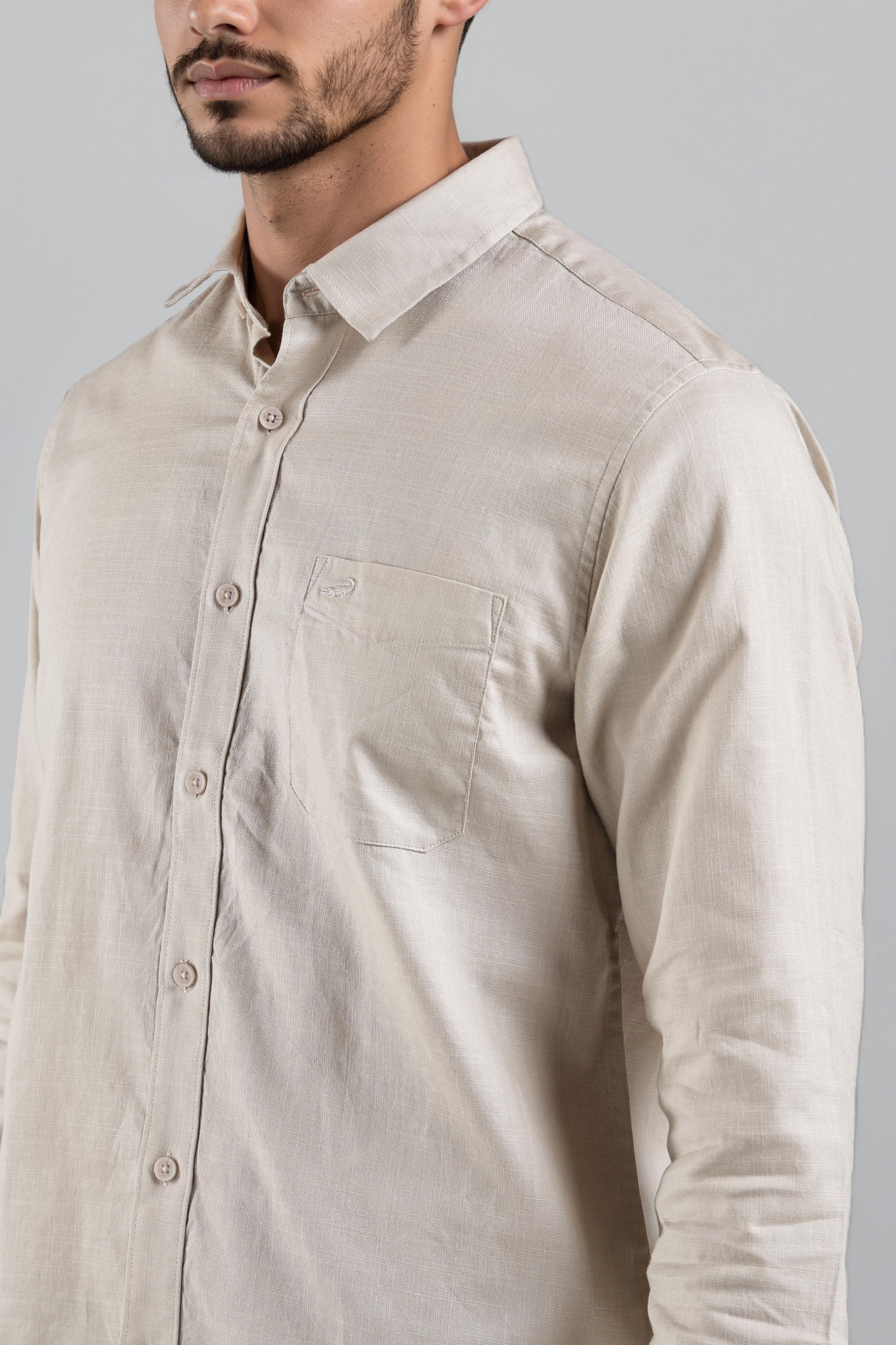 Beige shirt worn by a person on a gray background