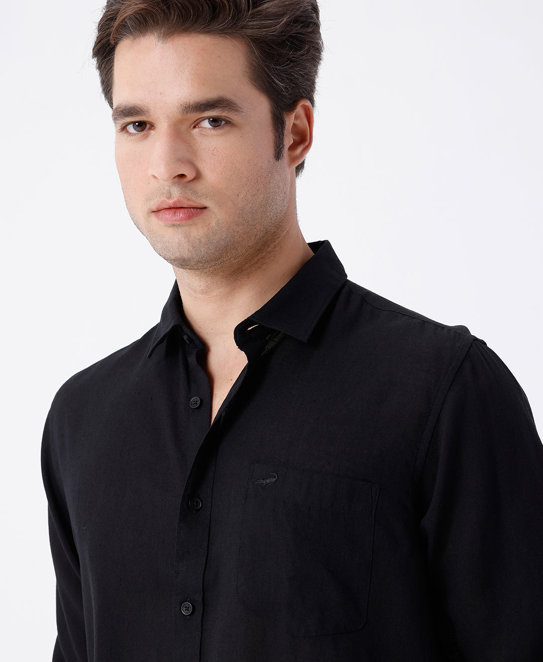 Man wearing a black linen blend shirt in black with casual styling on a gray background