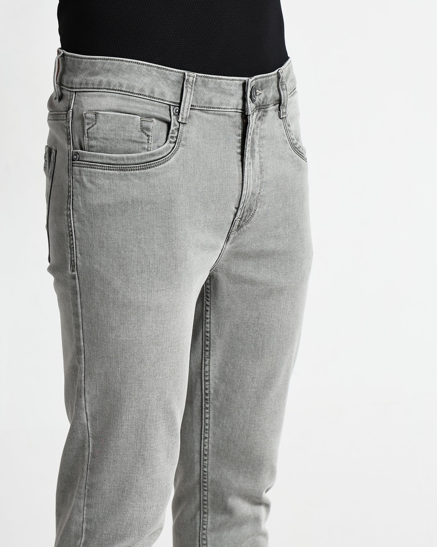 Gray jeans worn by a person on a white background