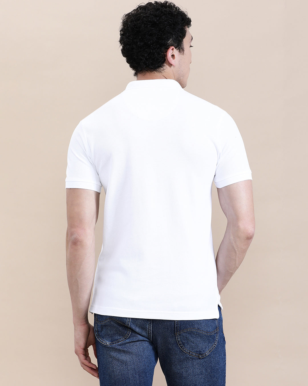 Man wearing a white white solid polo t shirt with pocket with casual styling on a gray background