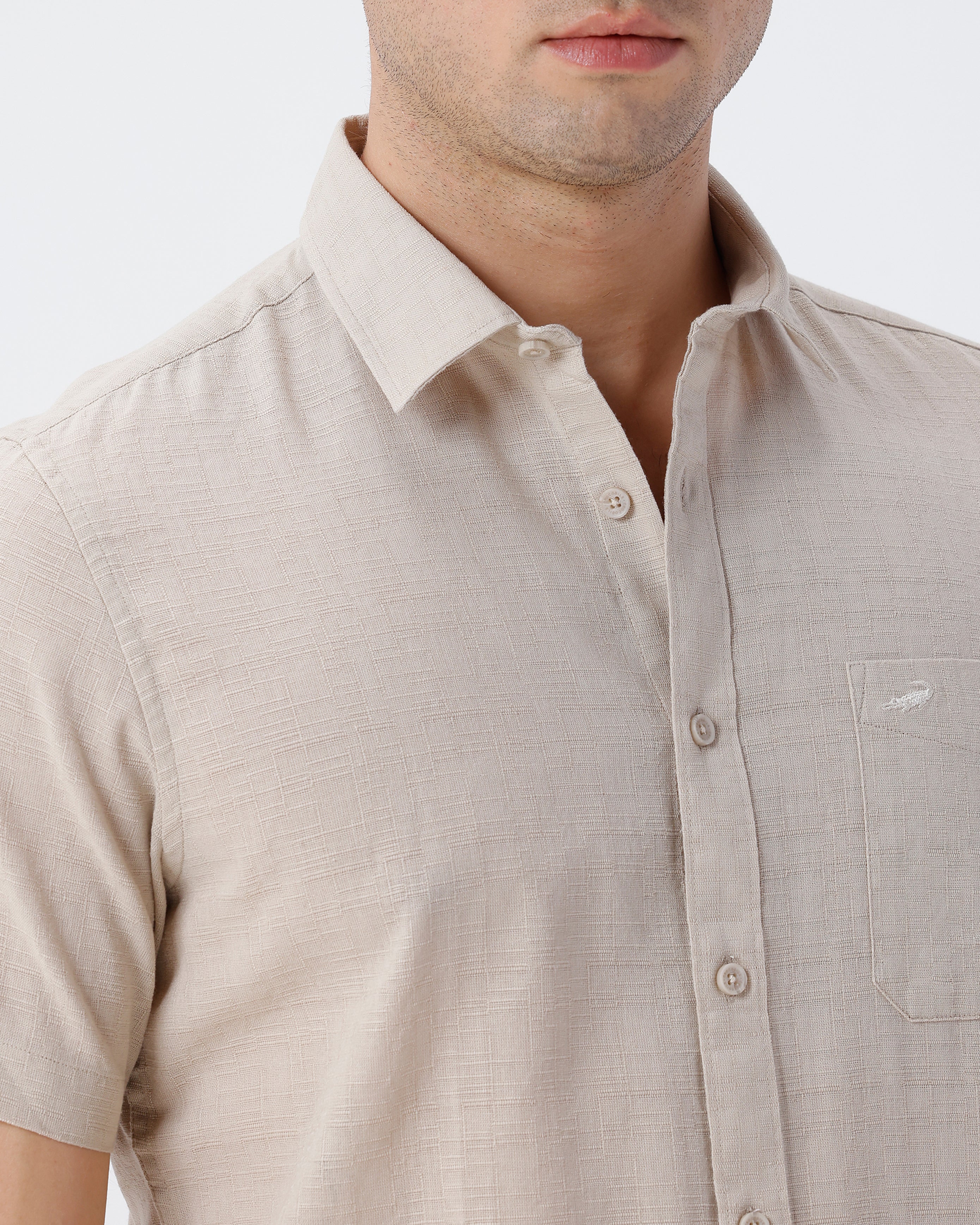 Man wearing a beige pure cotton textured shirt beige on a light gray background