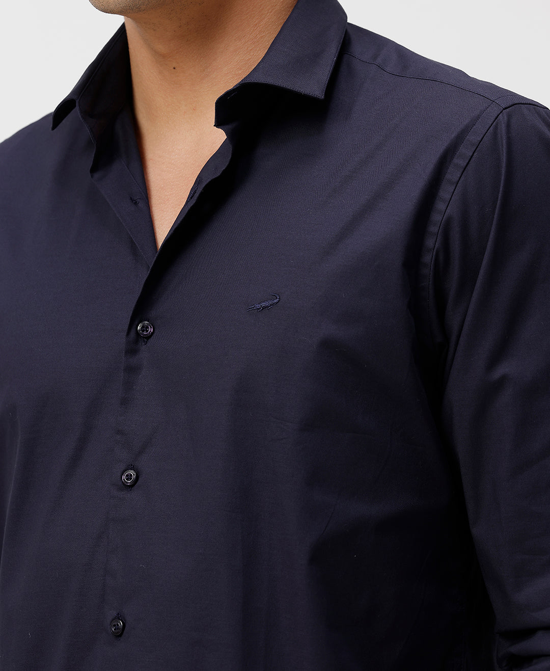 Man wearing a navy mercerized stretch shirt navy with casual styling on a gray background