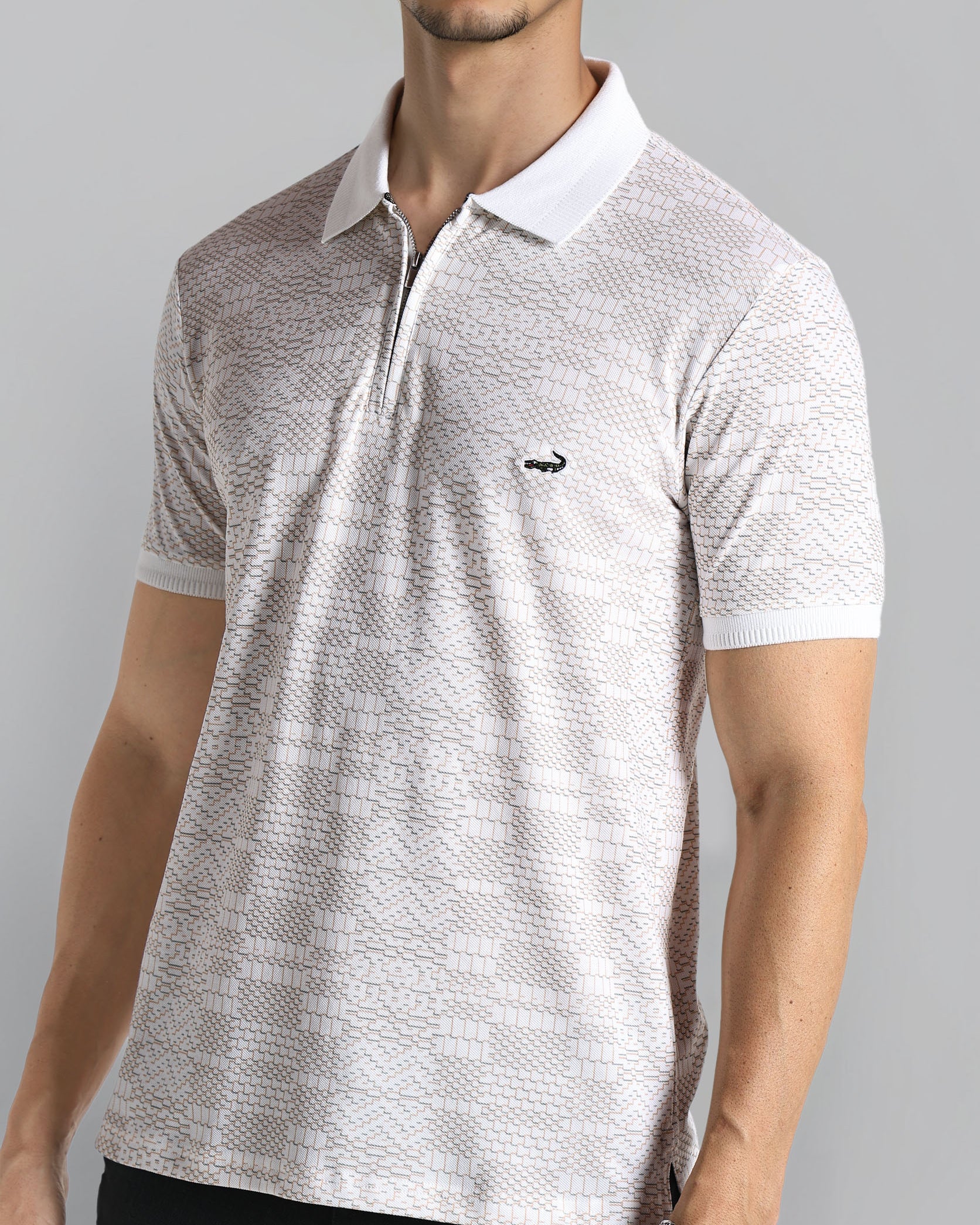 Man wearing a patterned polo shirt with a small logo on a gray background