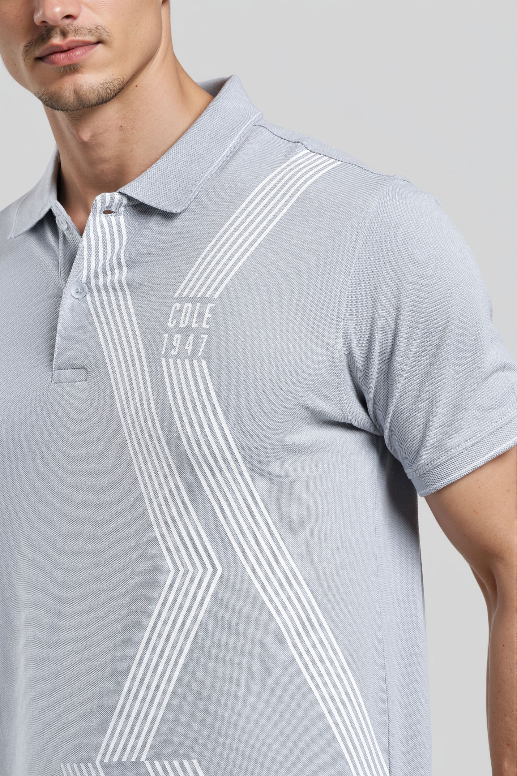 Gray polo shirt with white stripes and 'Cole 1847' branding on a plain background