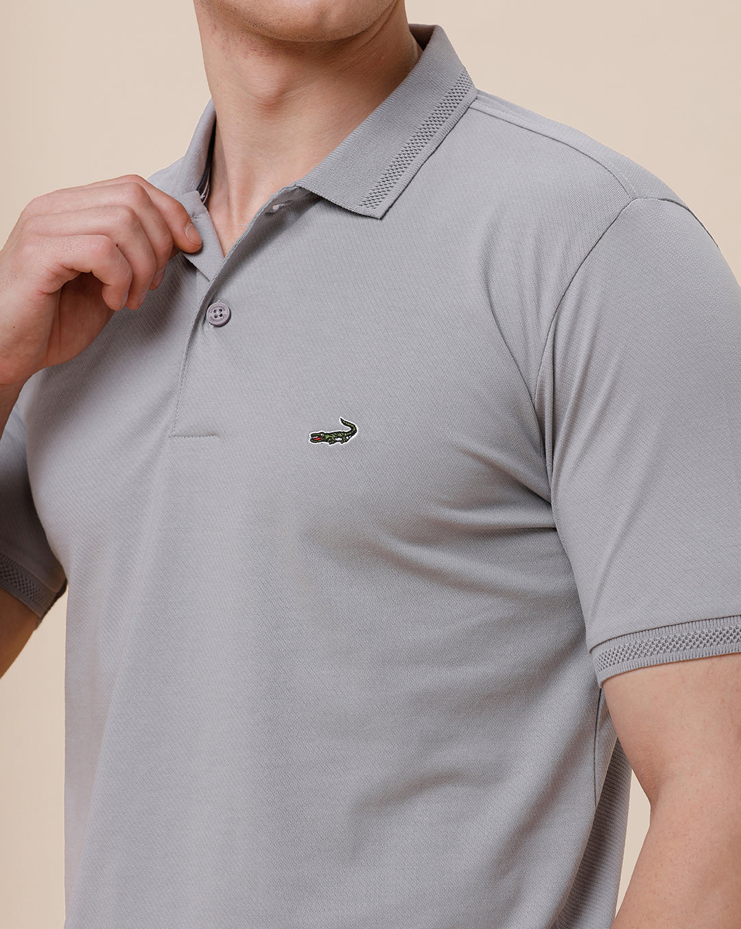 Man wearing a solid half sleeve casual polo t shirt on a light gray background