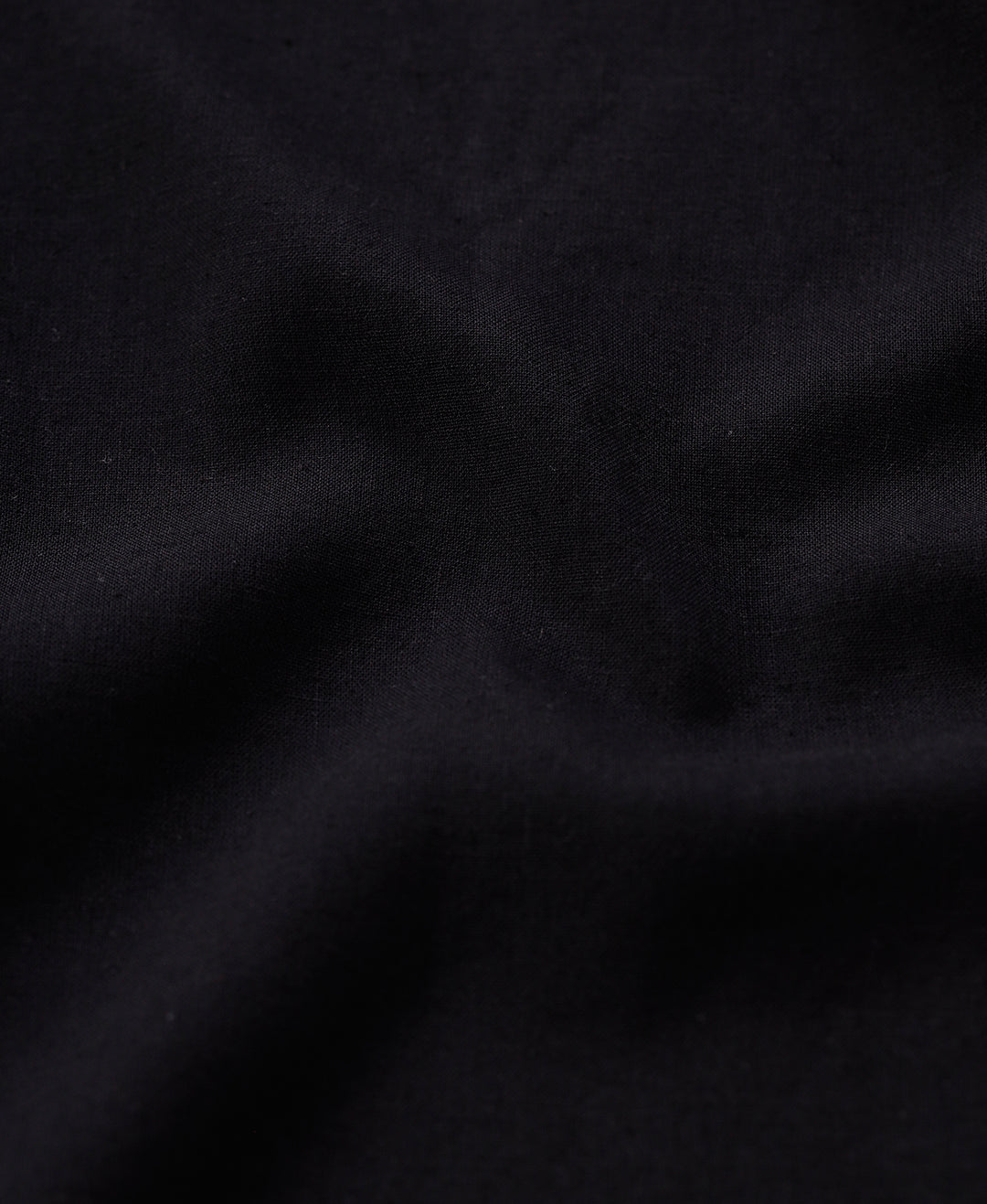 Man wearing a black linen blend shirt in black with casual styling on a gray background