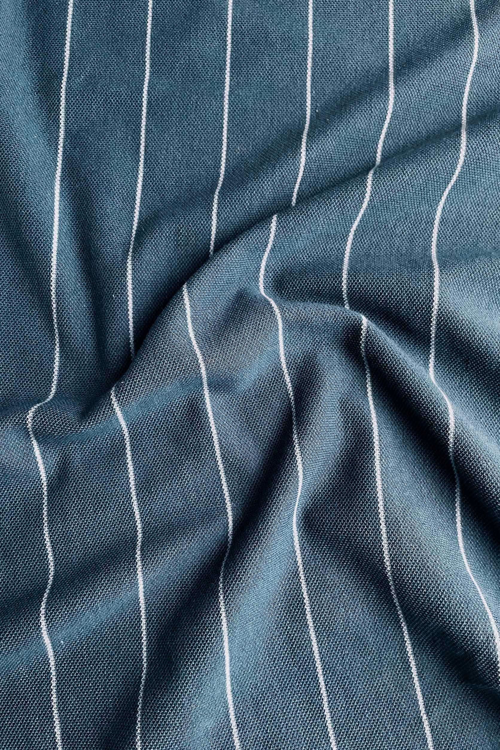 Close-up of blue fabric with white pinstripes