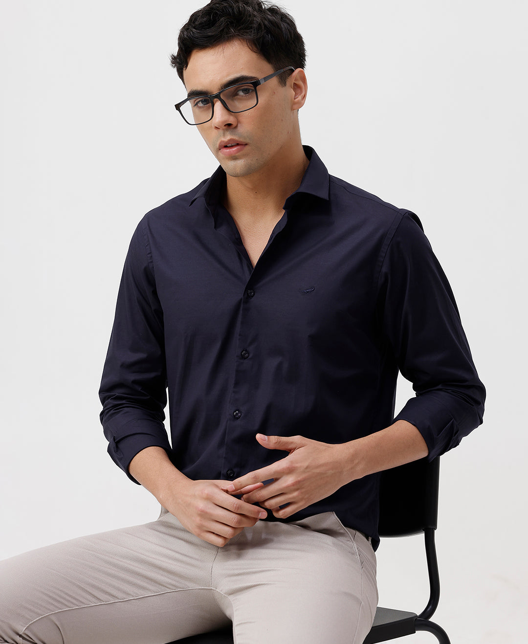 Man wearing a navy mercerized stretch shirt navy with casual styling on a gray background