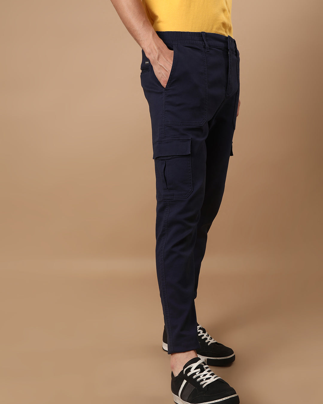 Man wearing a navy super soft navy cargo jogger with casual styling on a gray background