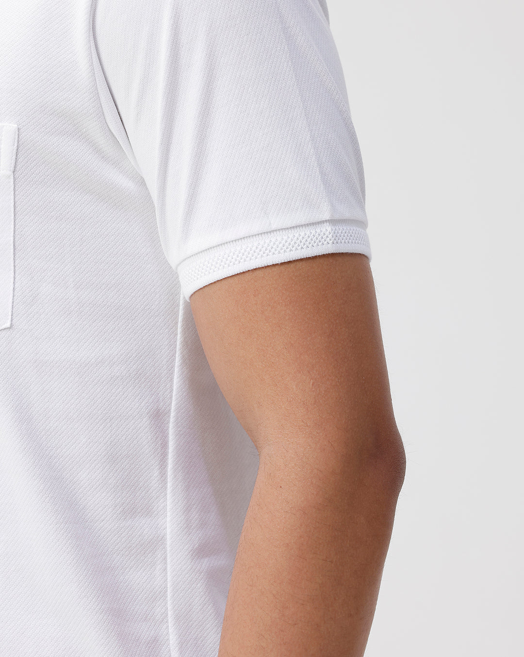 Man wearing a white solid white slim fit polo t shirt with casual styling on a gray background