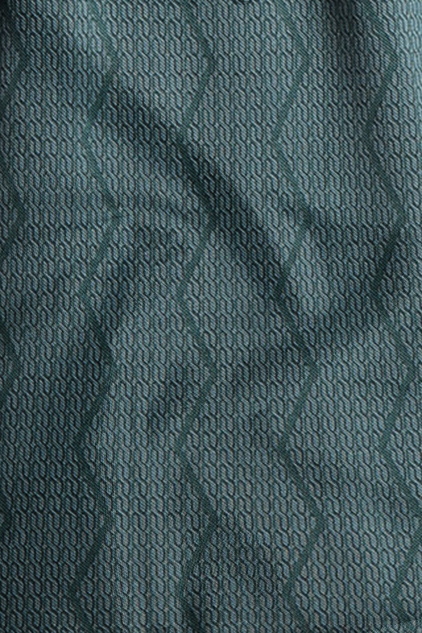 Close-up of textured teal fabric with a subtle pattern