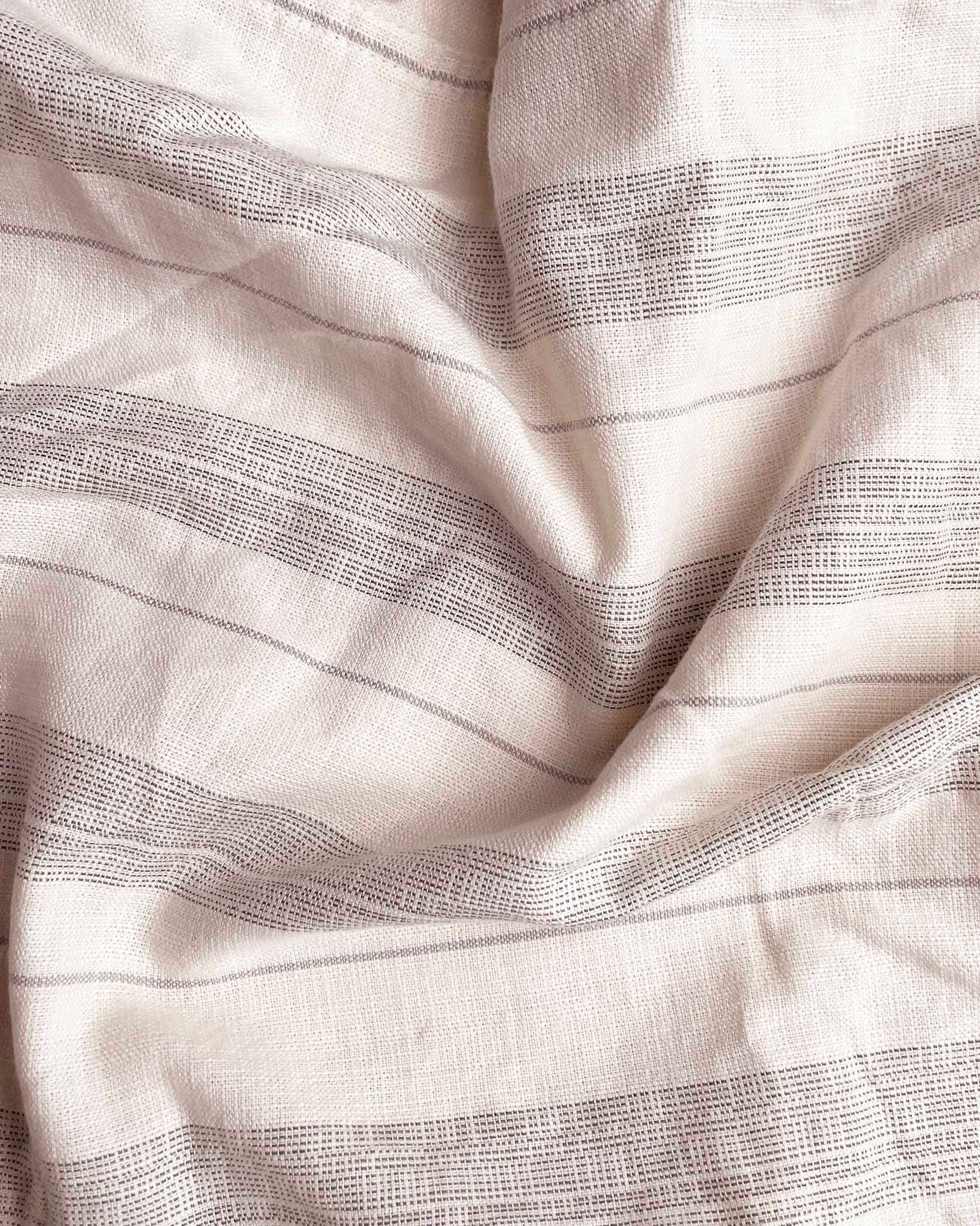 Close-up of white fabric with subtle black stripes