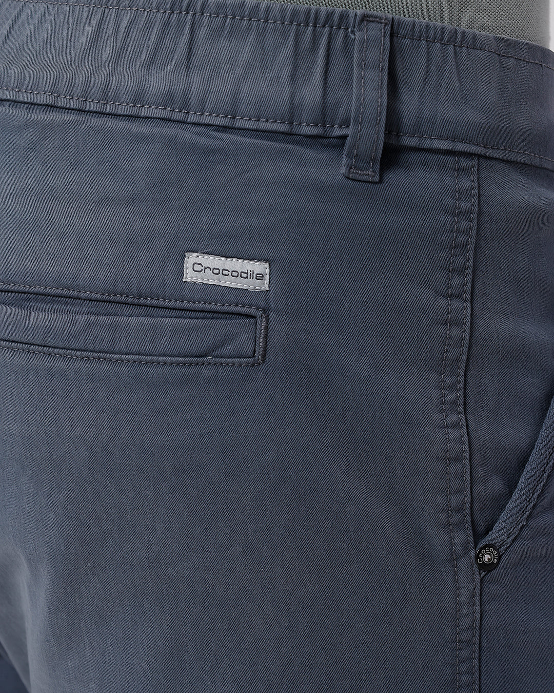 Man wearing a grey garment dyed cargo shorts in dark grey with casual styling on a gray background
