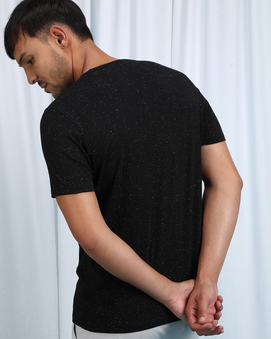 Man wearing a brown brown casual printed t shirt with casual styling on a gray background