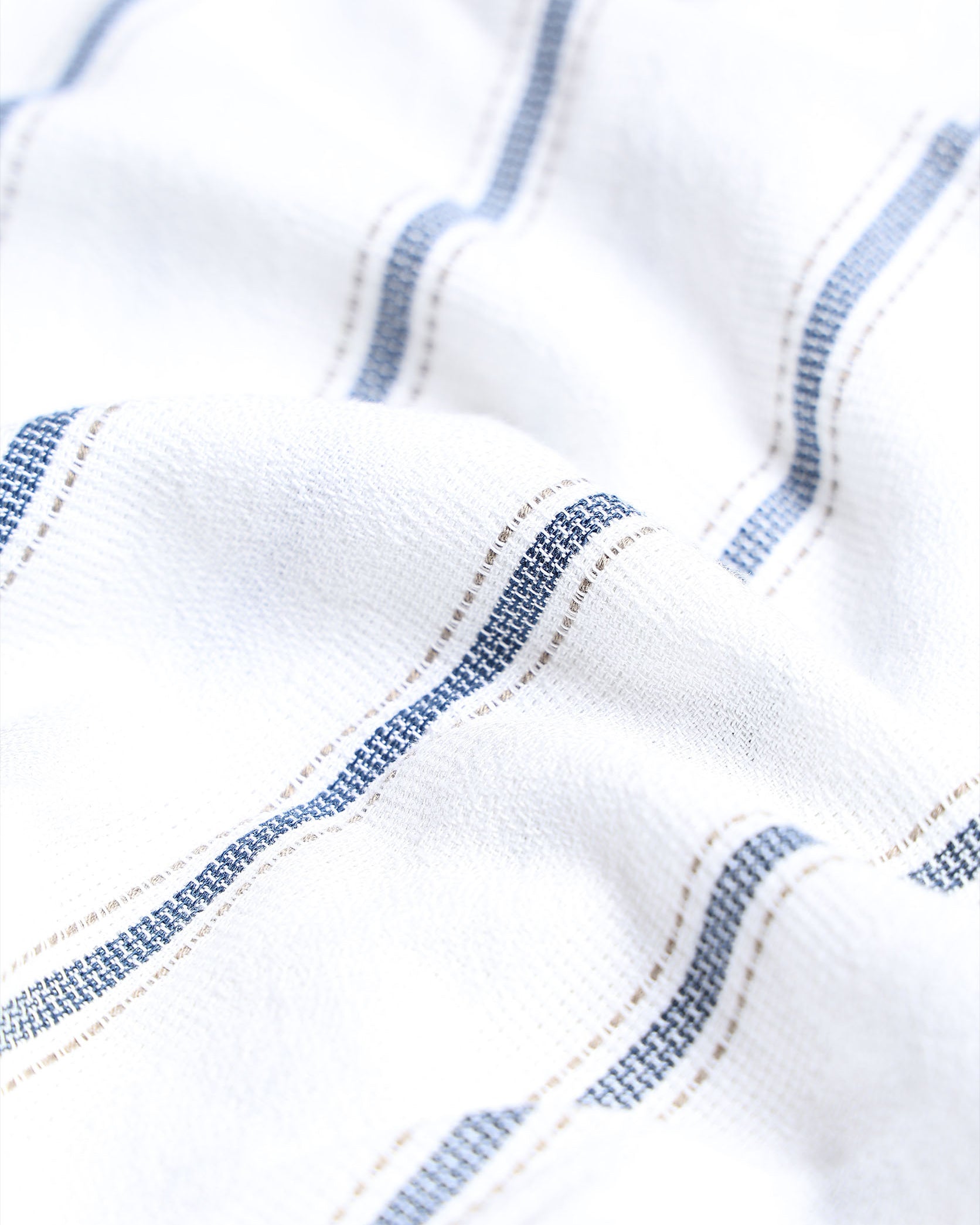 Close-up of white fabric with blue stitching