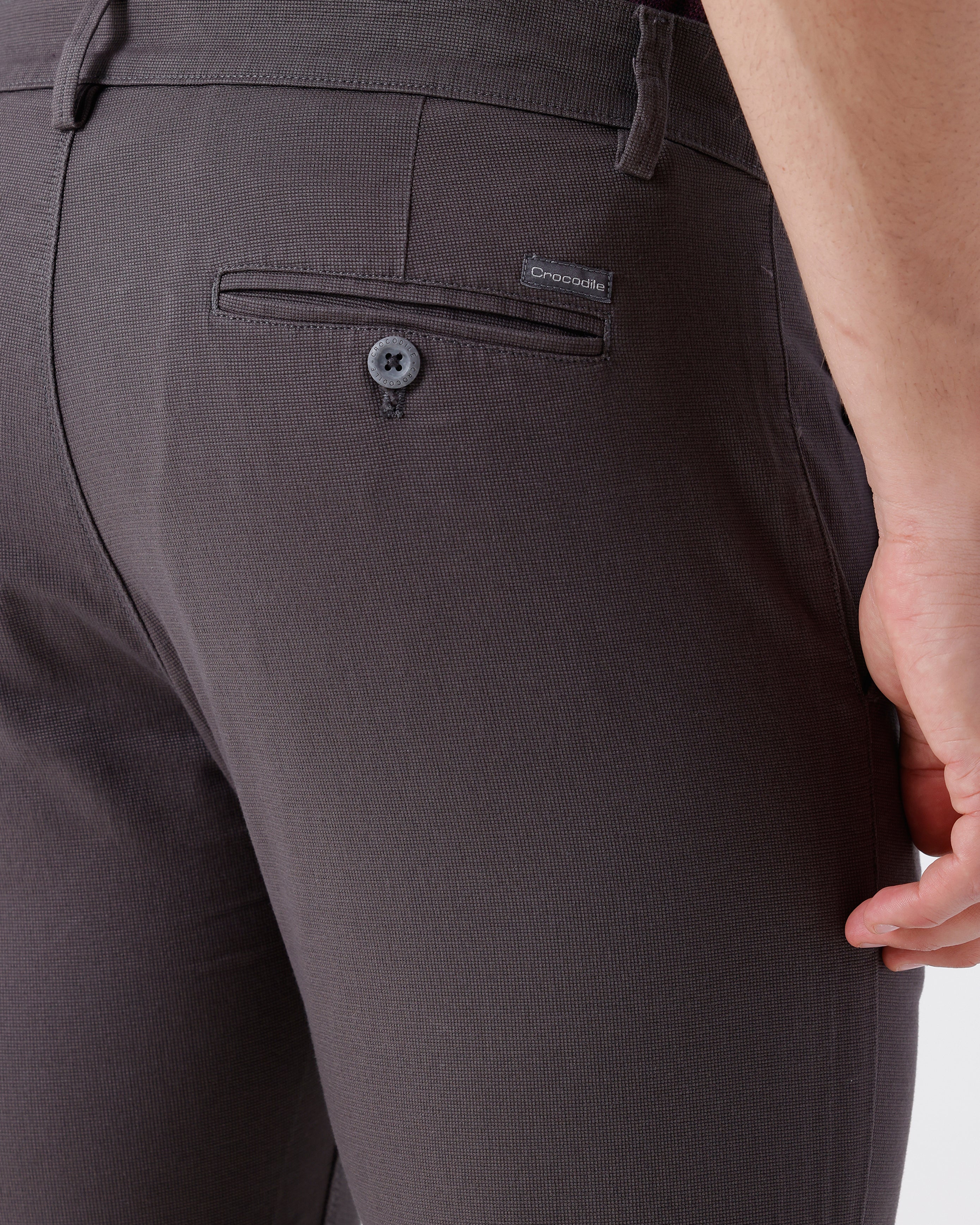 Woman wearing a grey textured essential chinos in dark grey with casual styling on a gray background