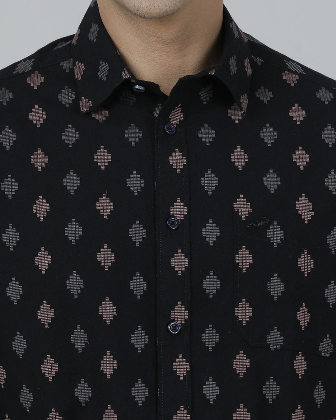 Man wearing a black black printed full sleeve shirt on a light gray background