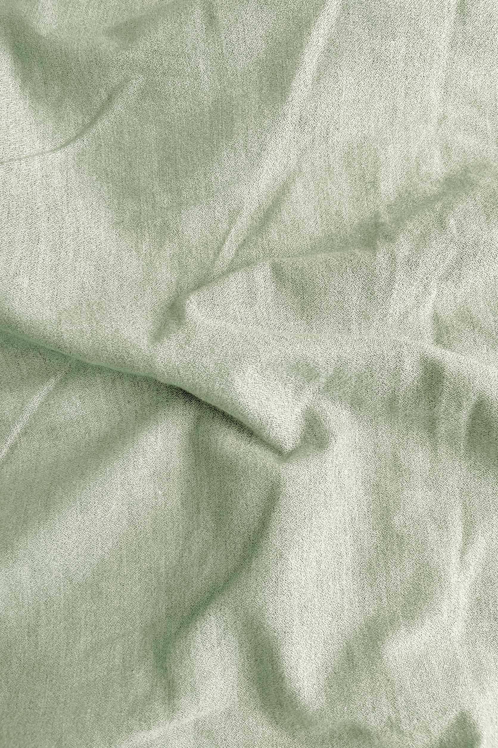 Close-up of light green fabric with folds