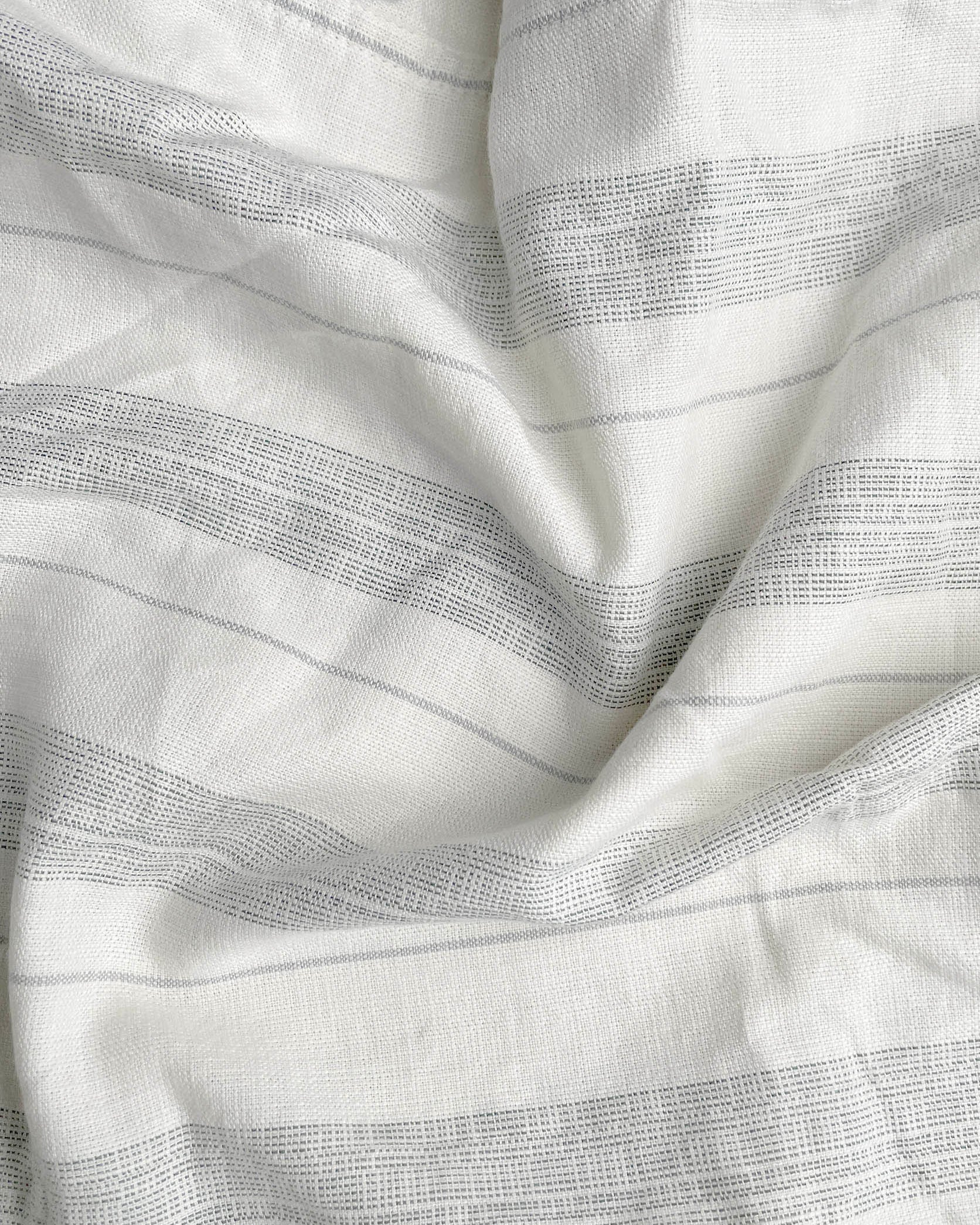 Close-up of white fabric with subtle gray stripes