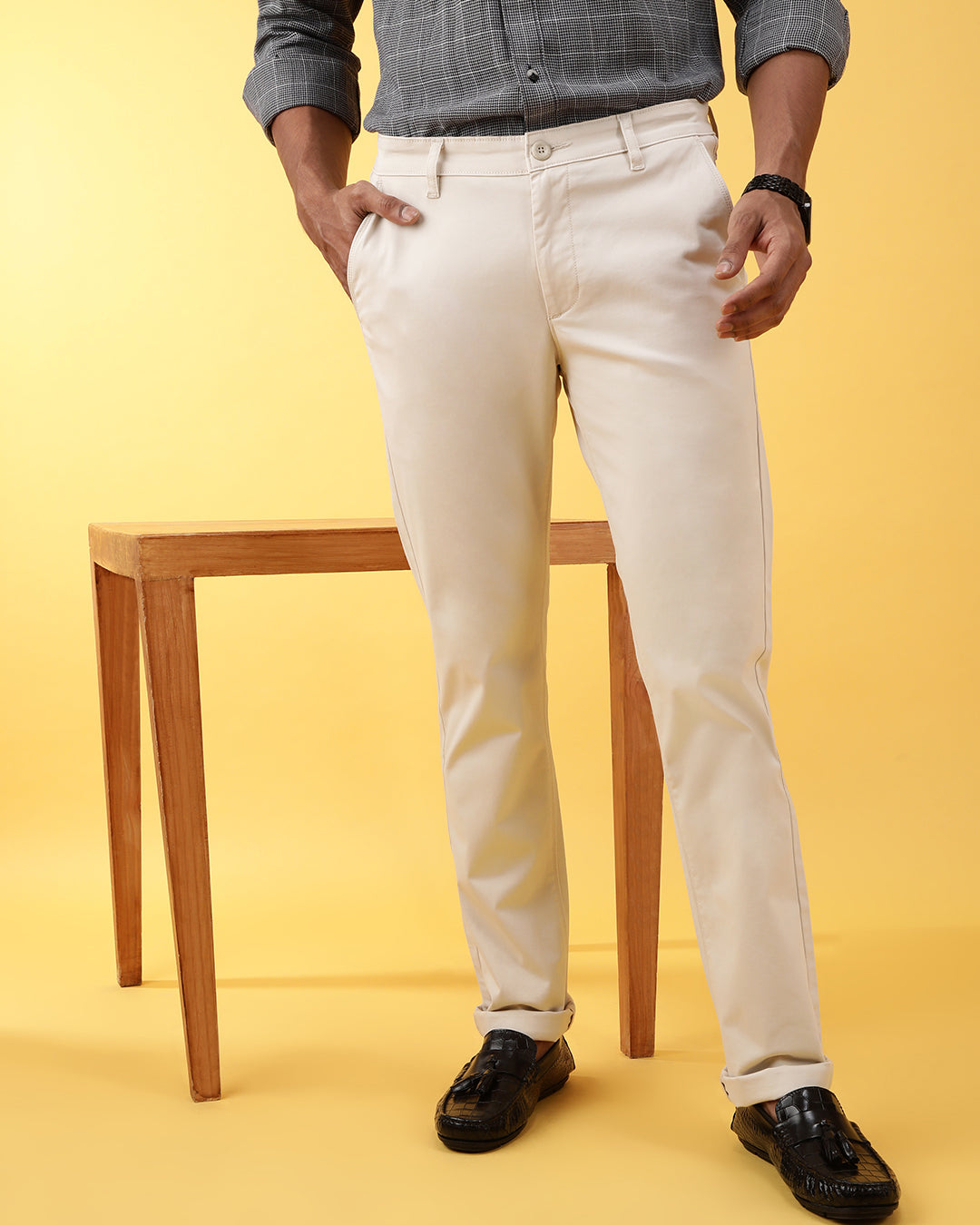 Man wearing a beige light beige solid slim fit casual trouser with casual styling on a gray background