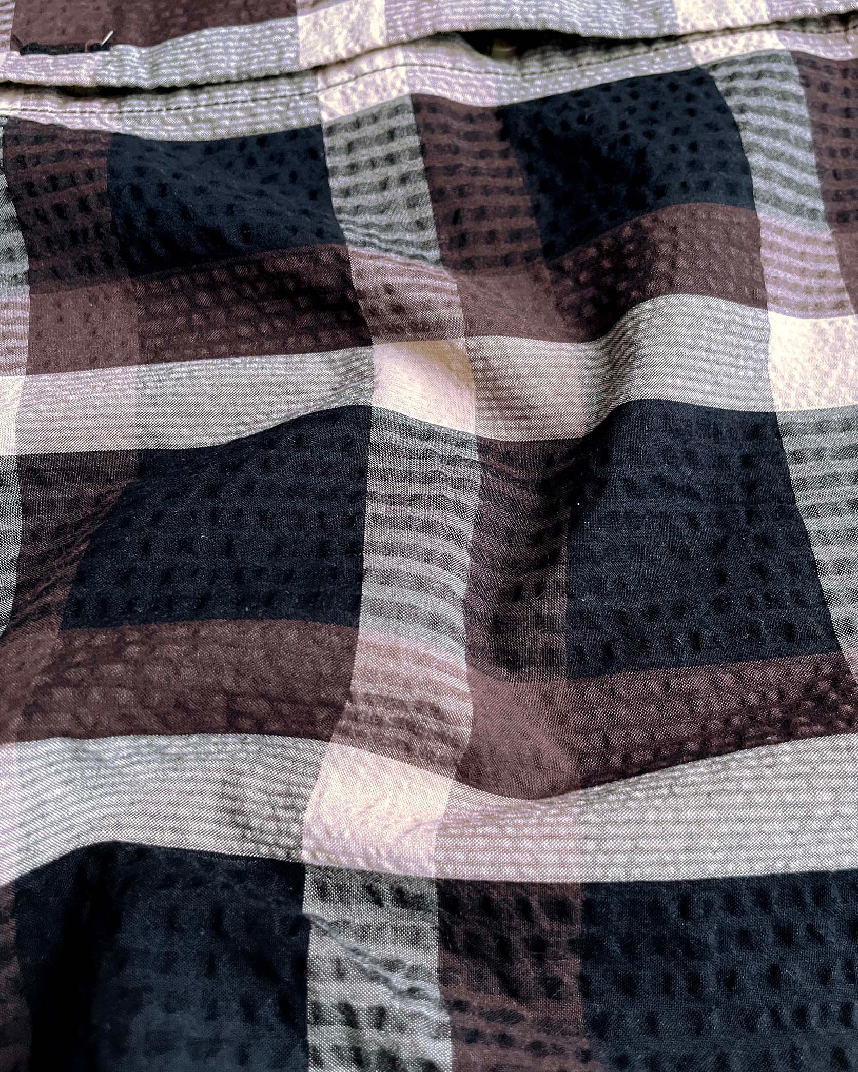 Close-up of checkered fabric with brown, black, and white pattern
