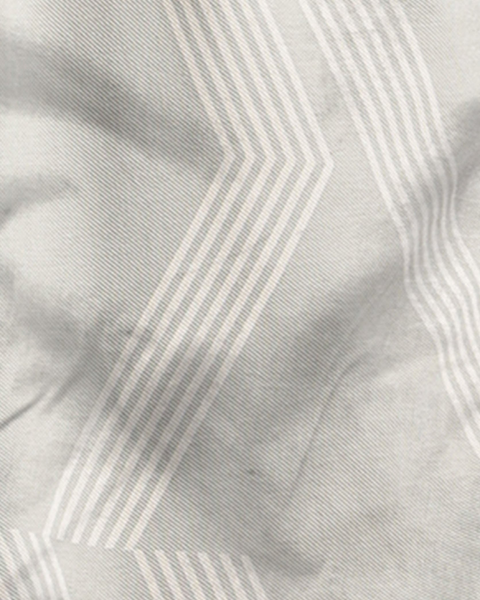 Close-up of fabric with a subtle pattern on a light gray background