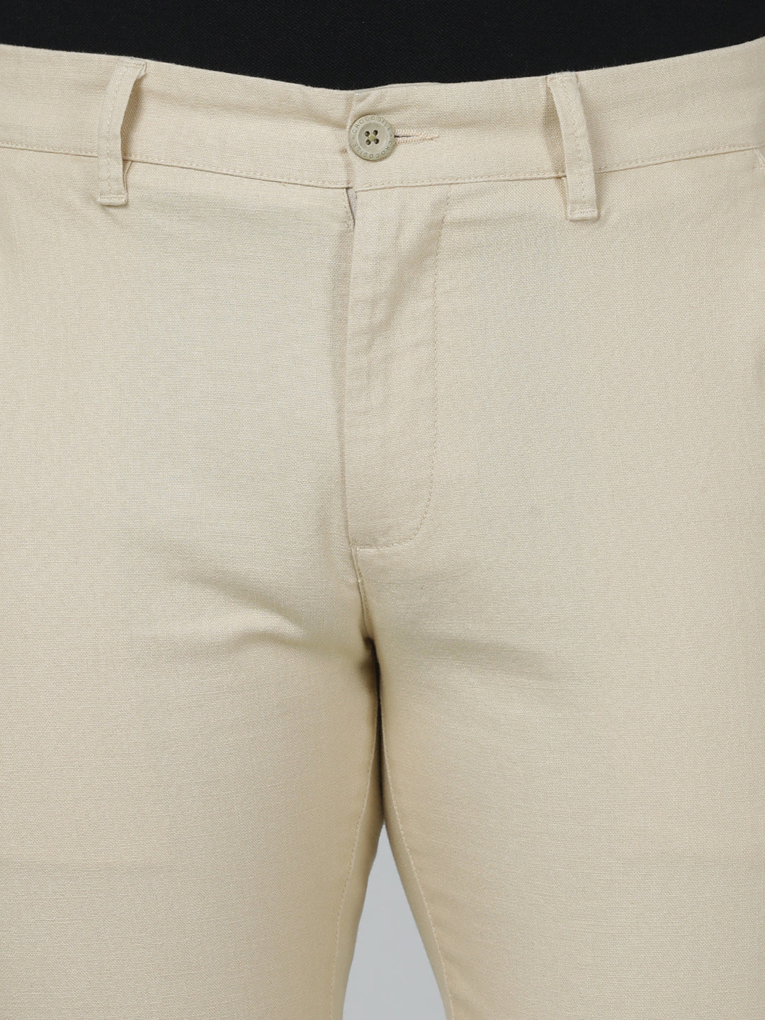 Man wearing a beige solid slim fit casual trouser beige with casual styling on a gray background