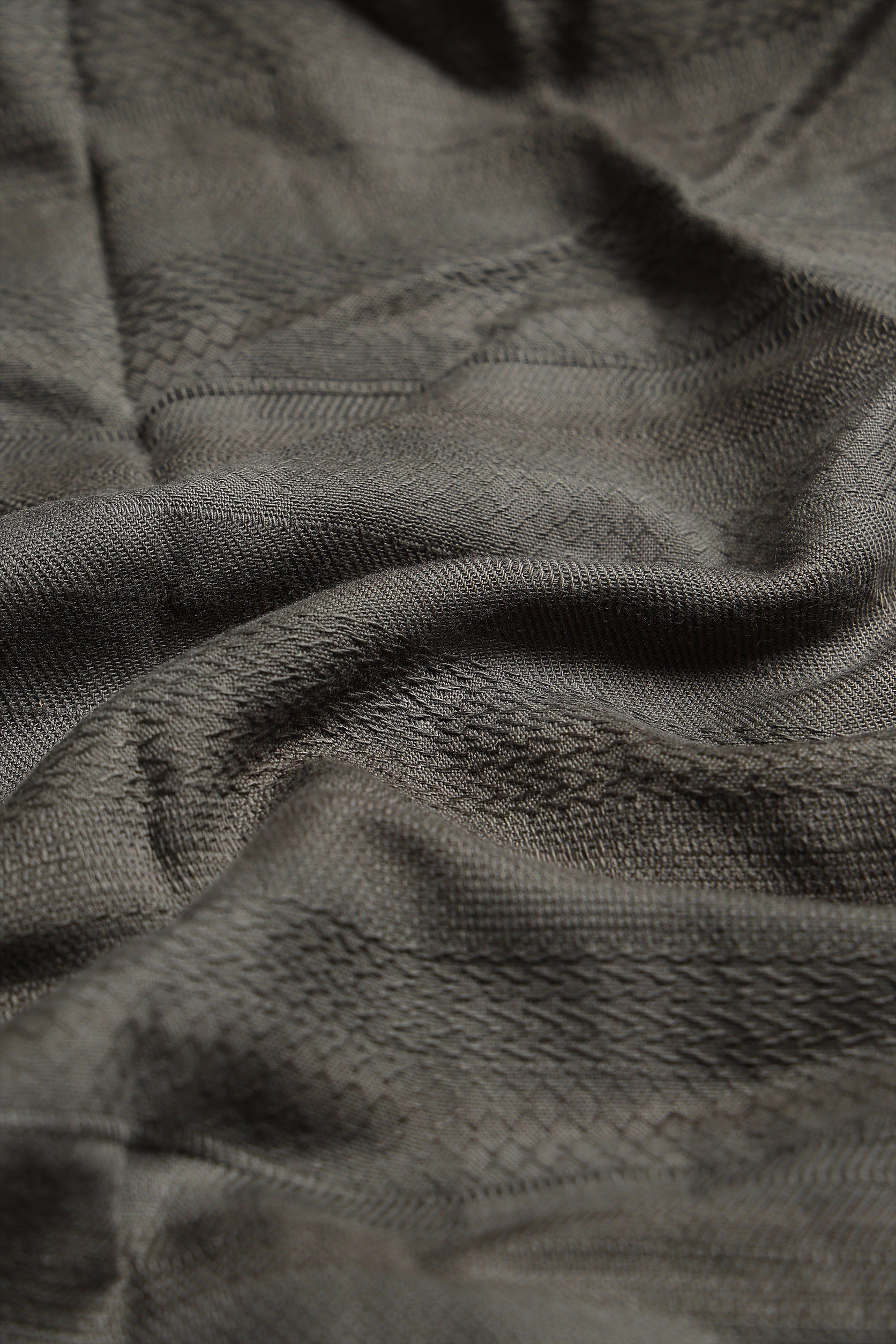 Close-up of textured dark green fabric with a subtle pattern