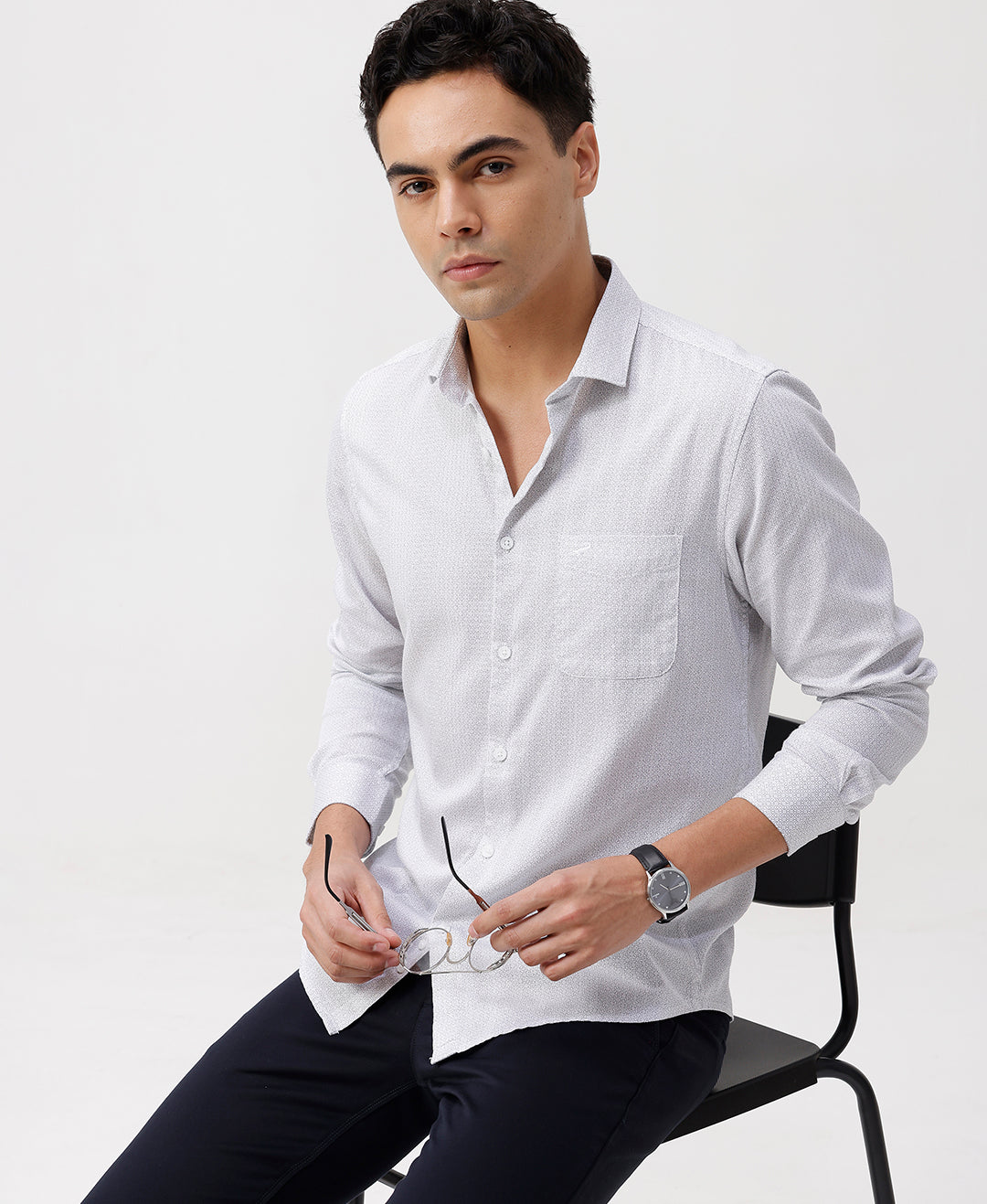 Man wearing a white white all over print slim fit casuals shirts with casual styling on a gray background