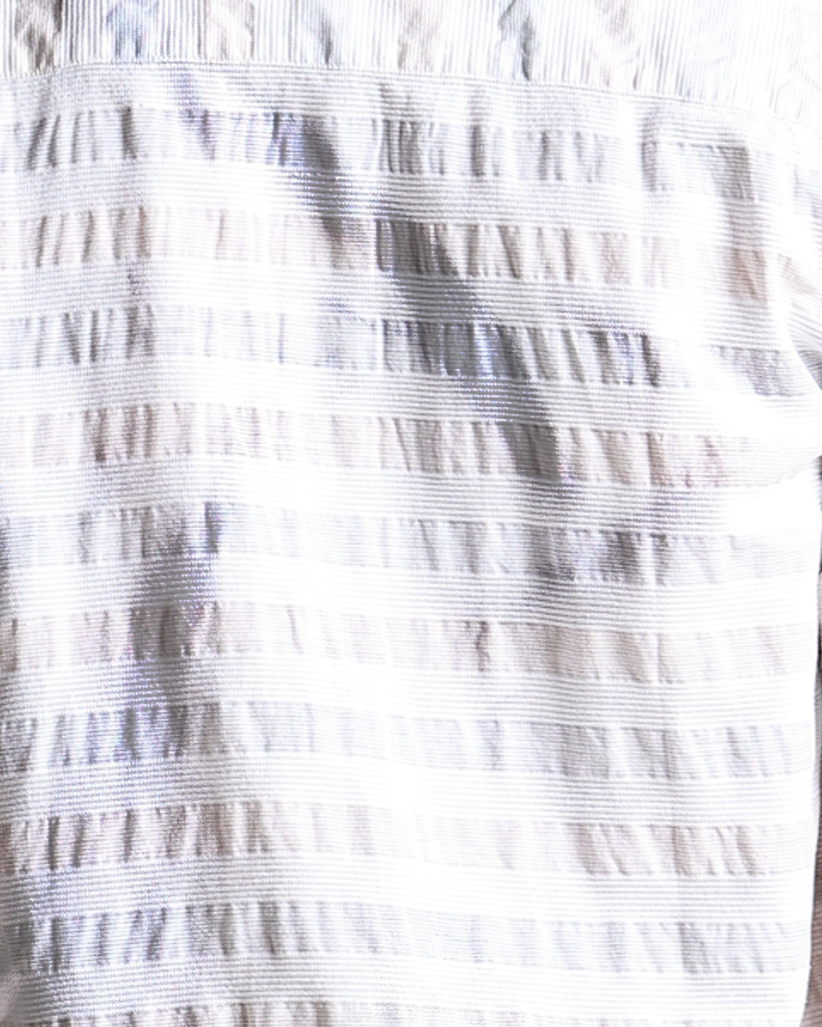Close-up of a textured white fabric with a subtle pattern