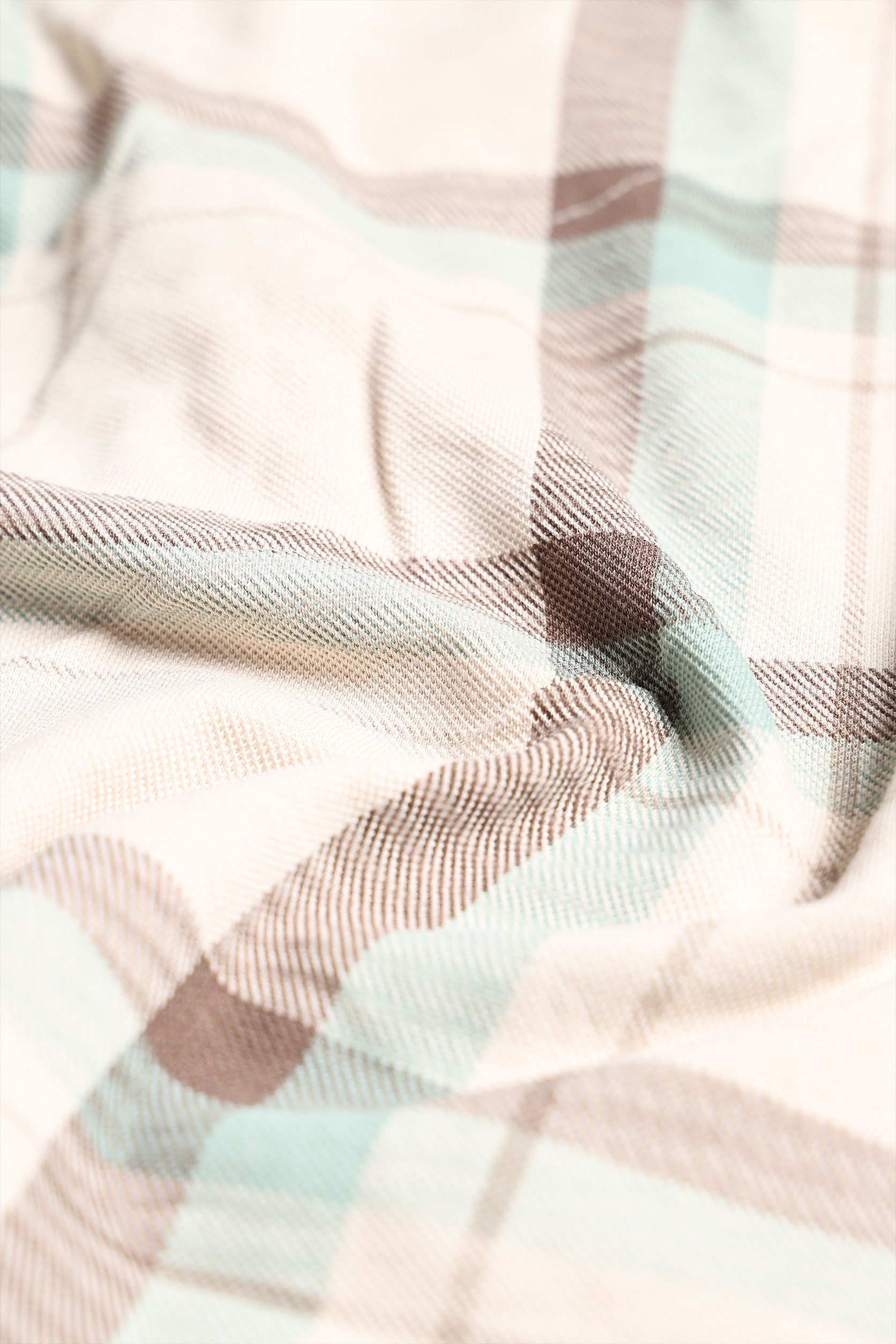 Close-up of a plaid fabric with pink, green, and brown colors.